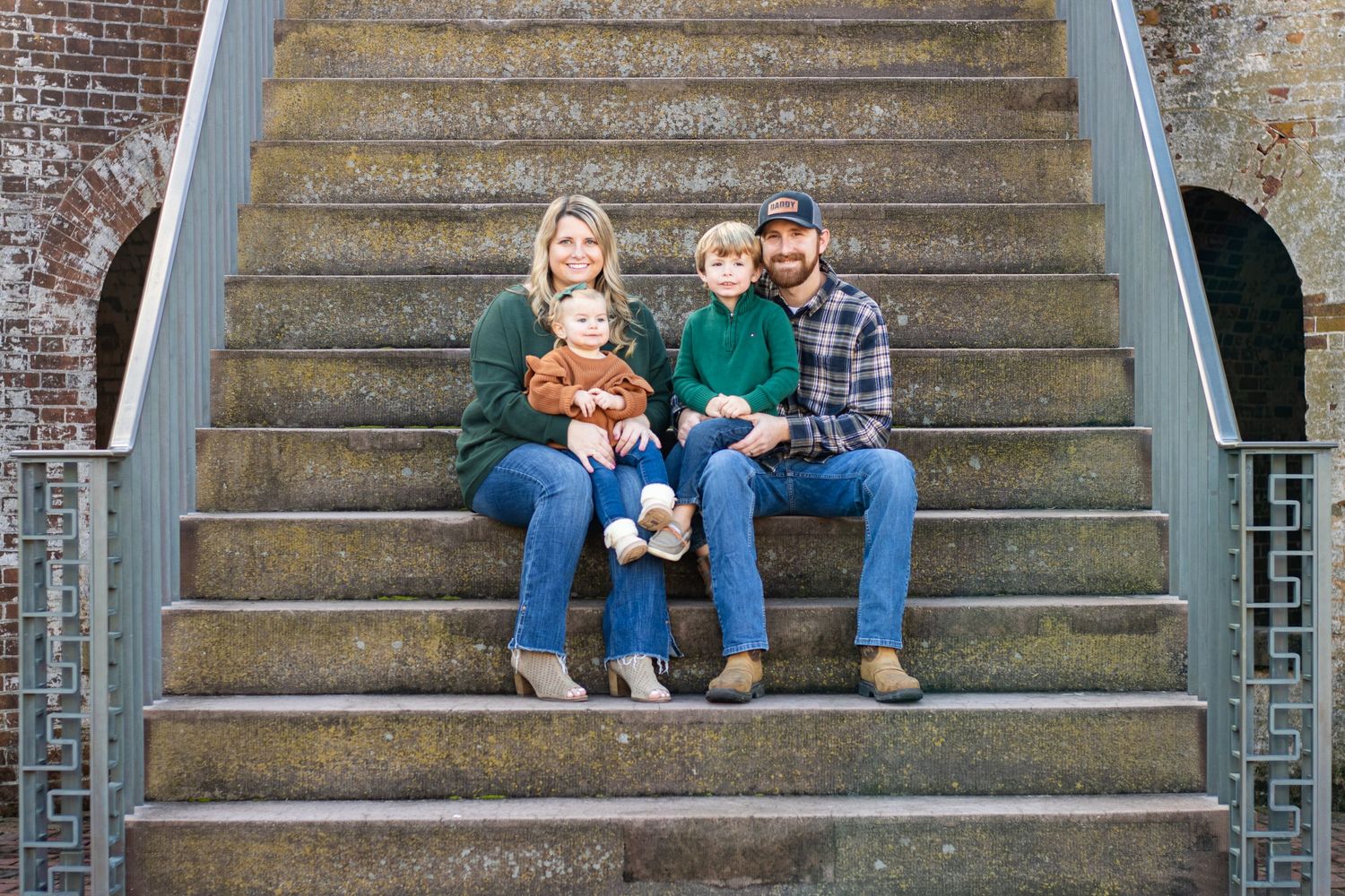 A family poses together in a rustic brick archway during a casual outdoor photo session.
Portraits, family photography