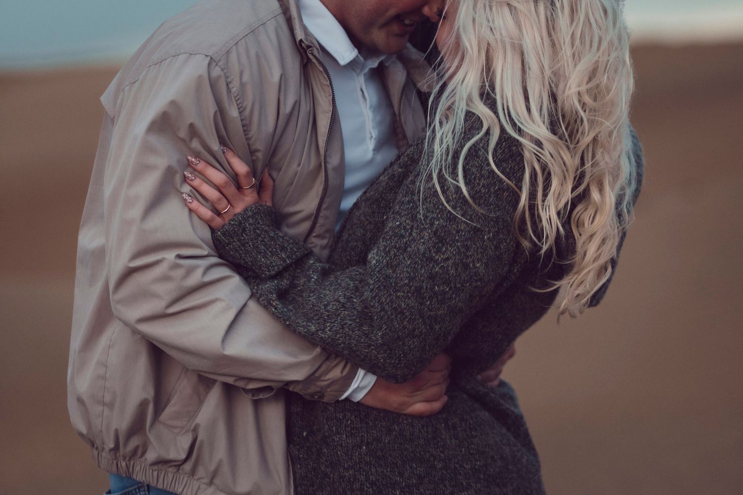 Couple visiting PEC in Spring are photographed dressed in layers on Sandbanks beach before crowds and tourism season kicks into high gear.