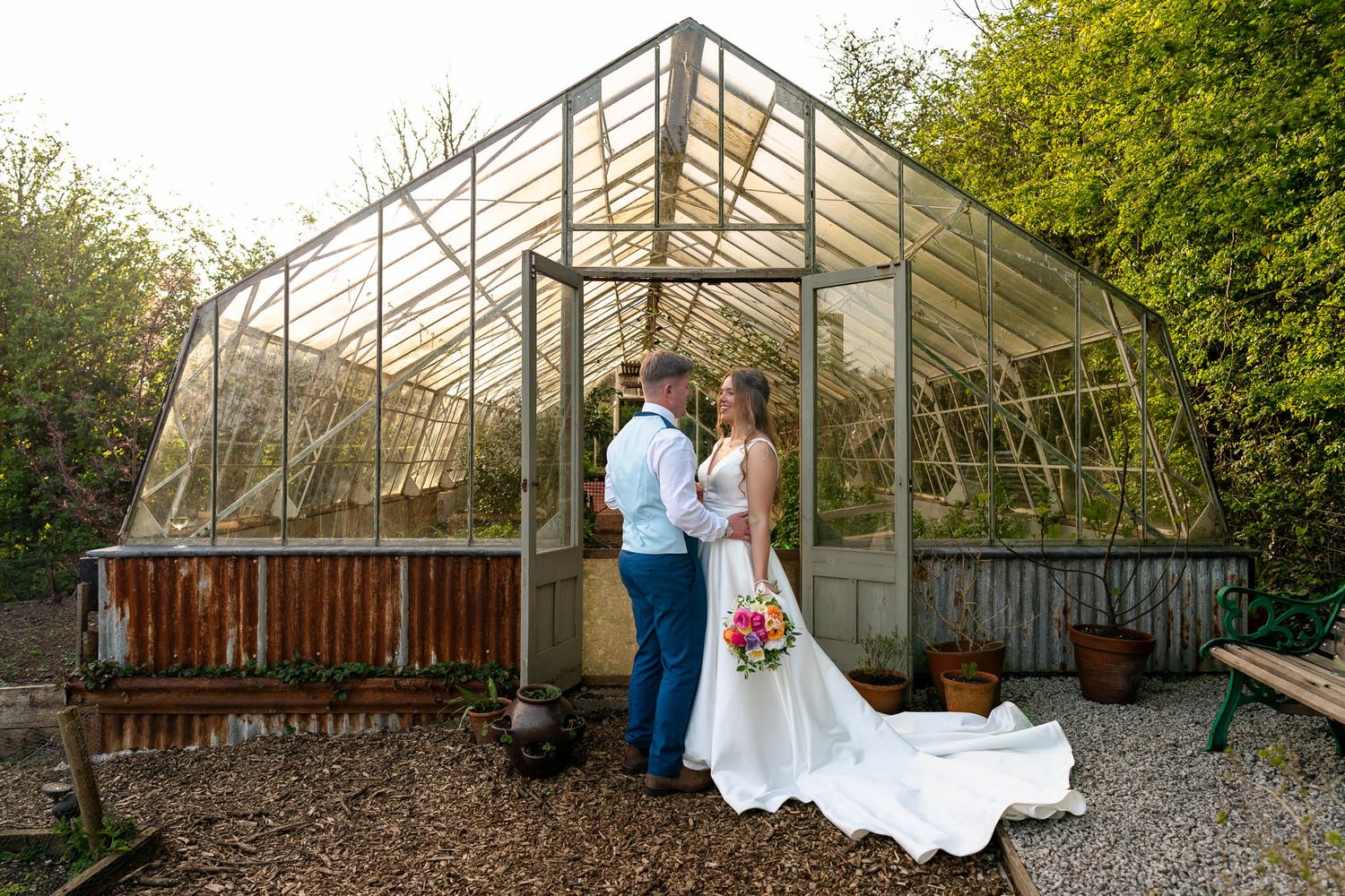 Newly married couple in front of greenhouse at Nancarrow Farm Weddings Truro