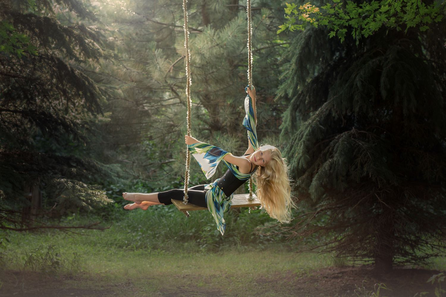 Creative Sioux Falls, SD photographer constructs swing in backyard for photo shoot with a child circus arts aerial artist performer.