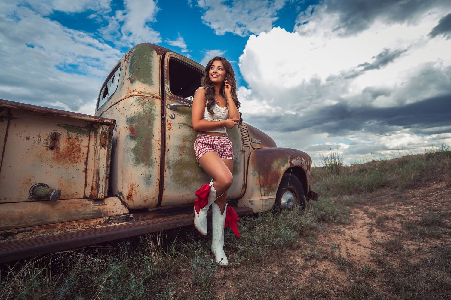A vintage rusty train car sits abandoned in a desert landscape against dramatic cloudy skies.
