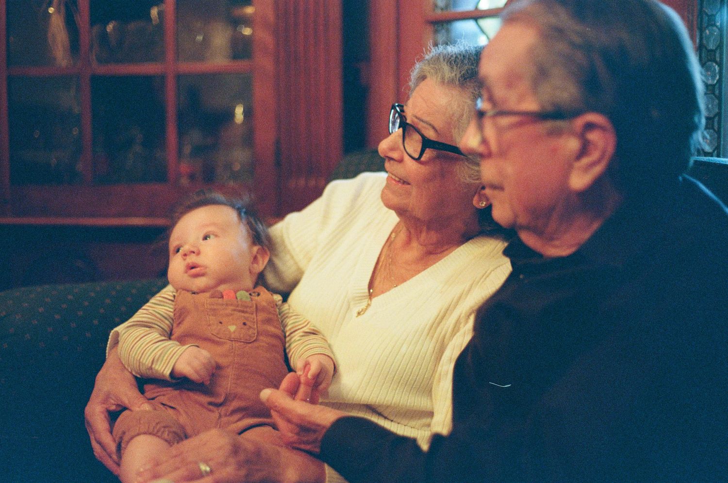 A series of vintage photographs showing a baby with family members in warm, nostalgic lighting.