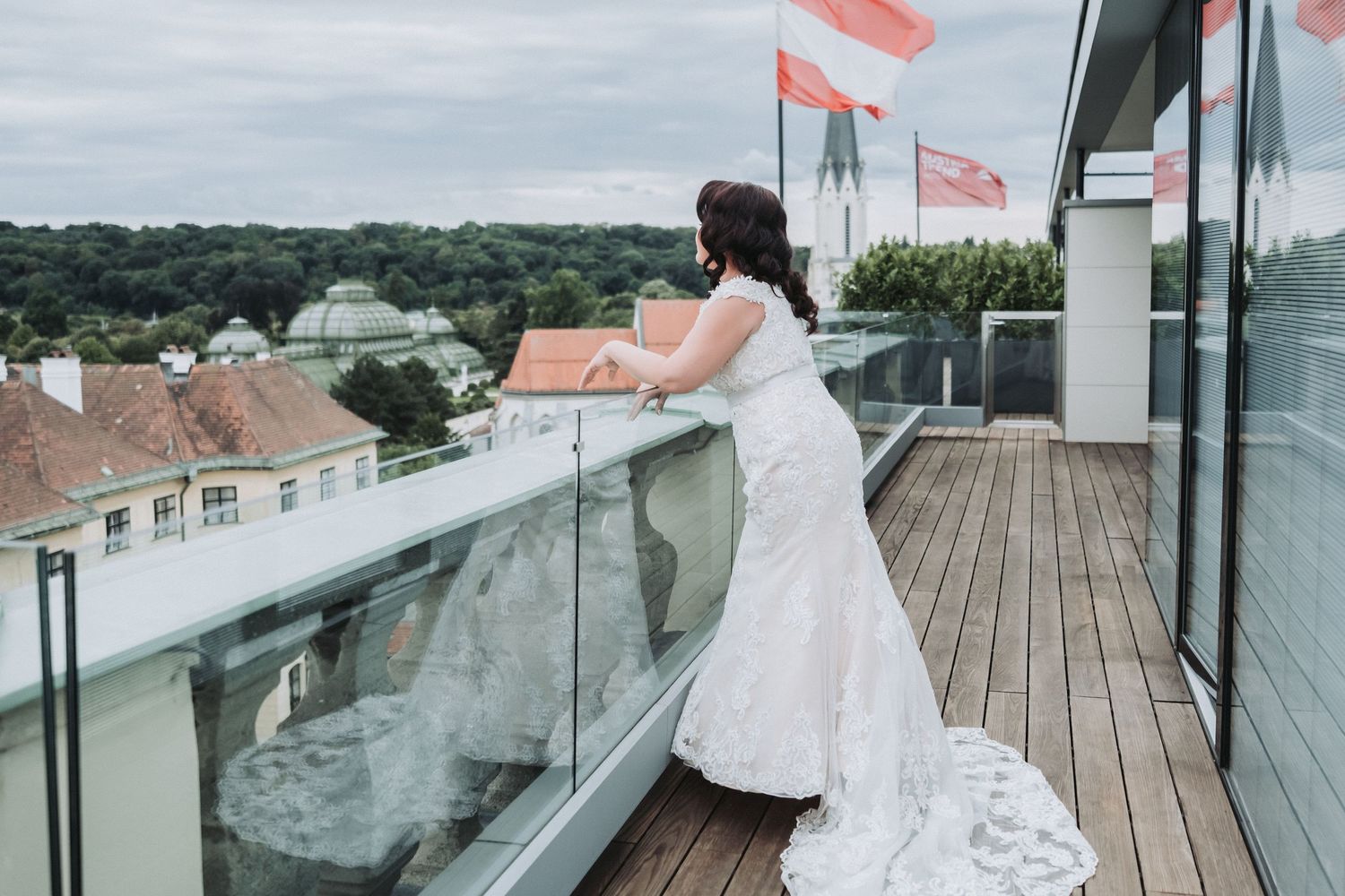 A scenic wedding ceremony setup on a rooftop deck overlooking a lush green landscape with white chairs and floral decor.