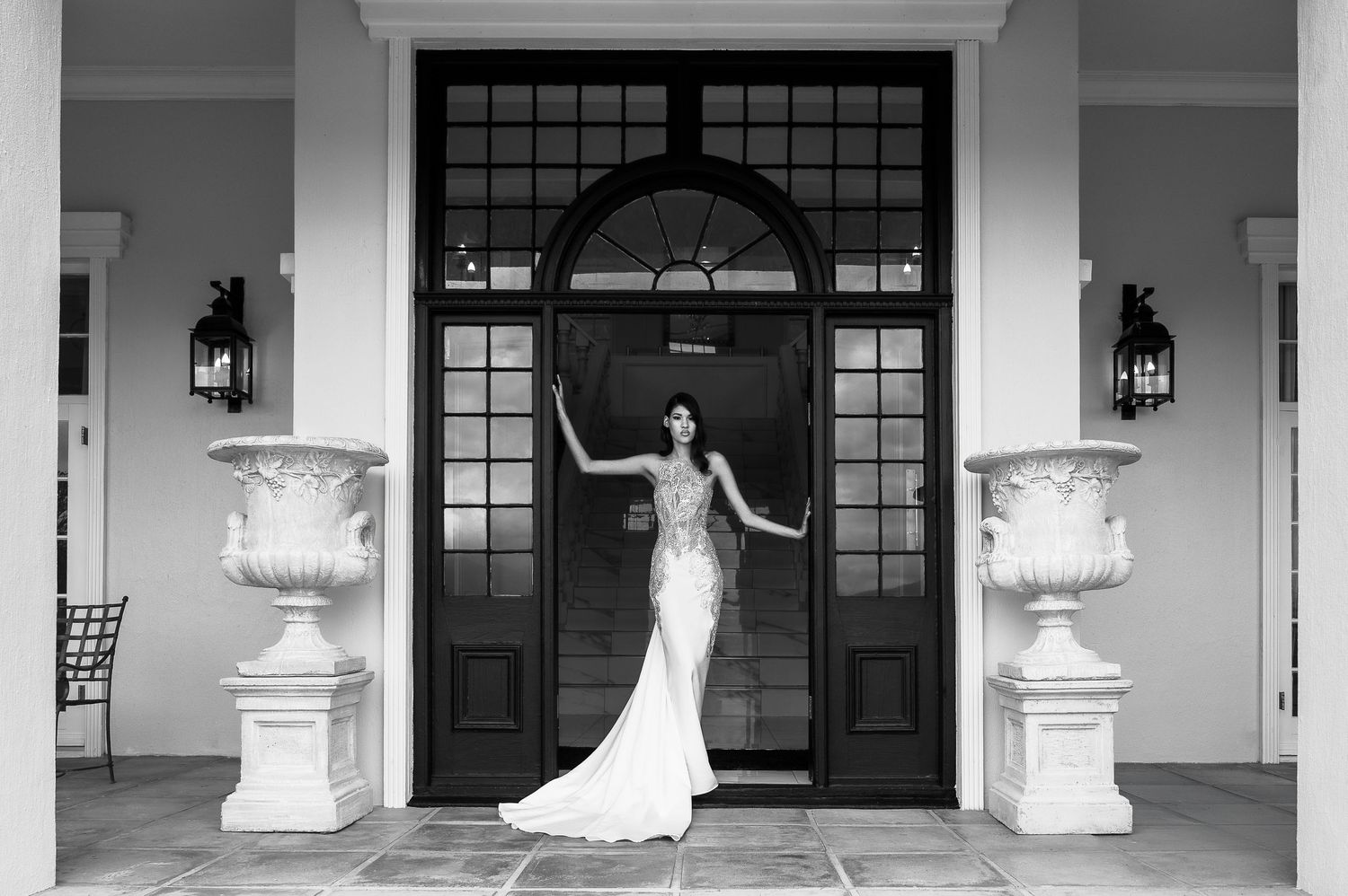 A stunning embellished wedding dress with intricate beading and ethereal design photographed in an elegant white setting.