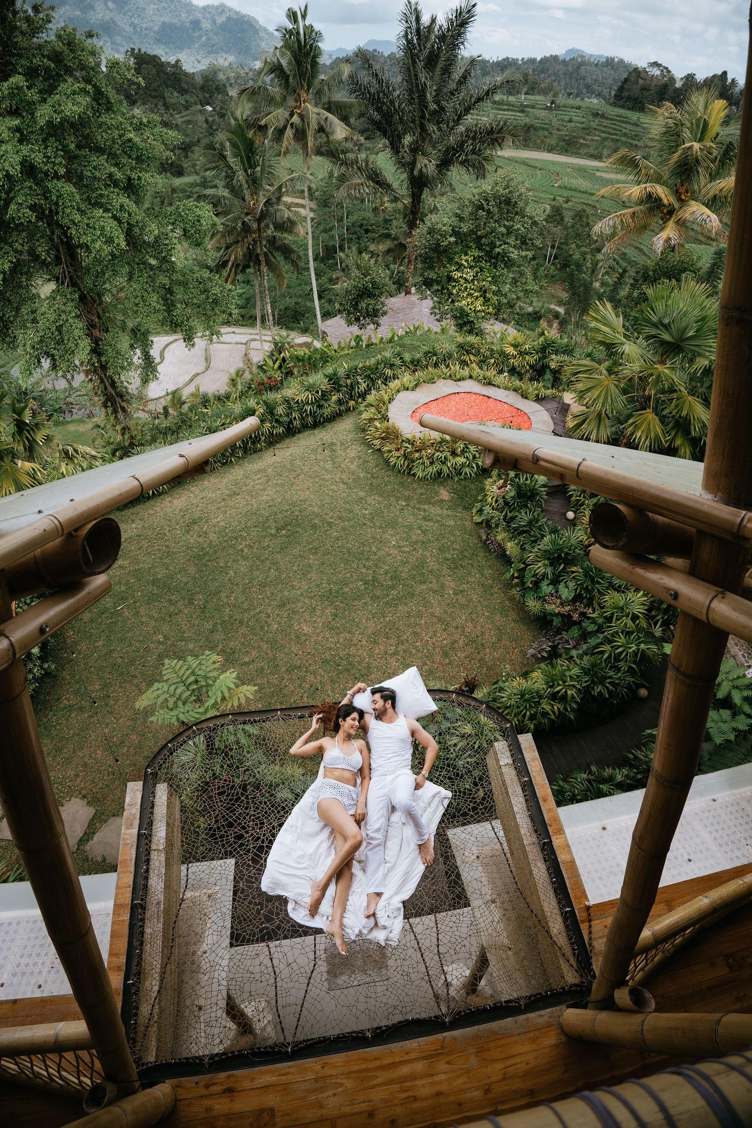 Elevated view of a wooden observation deck surrounded by palm trees and tropical greenery.