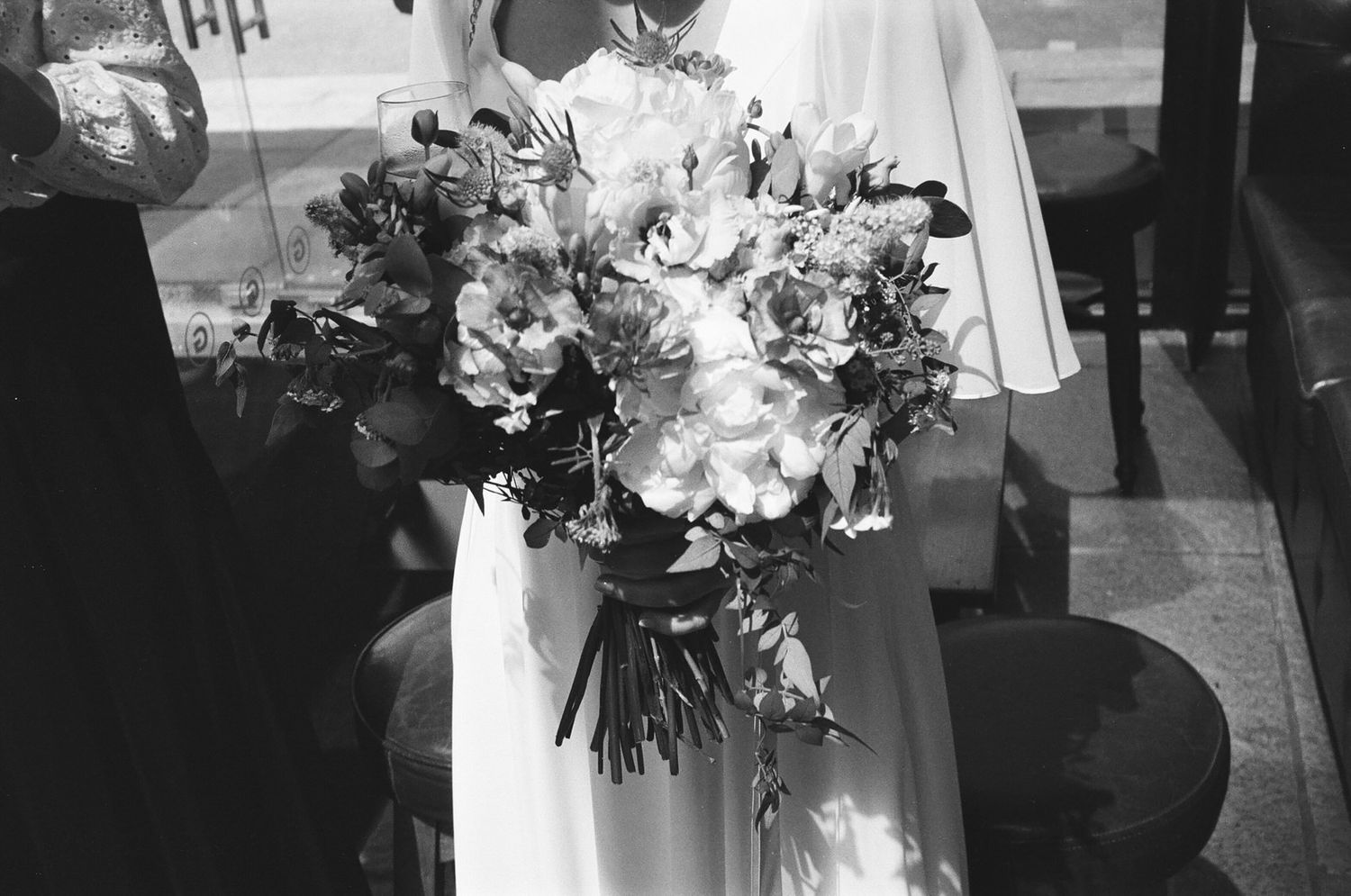 A joyful person sings into a microphone at a gathering, captured in black and white photography.