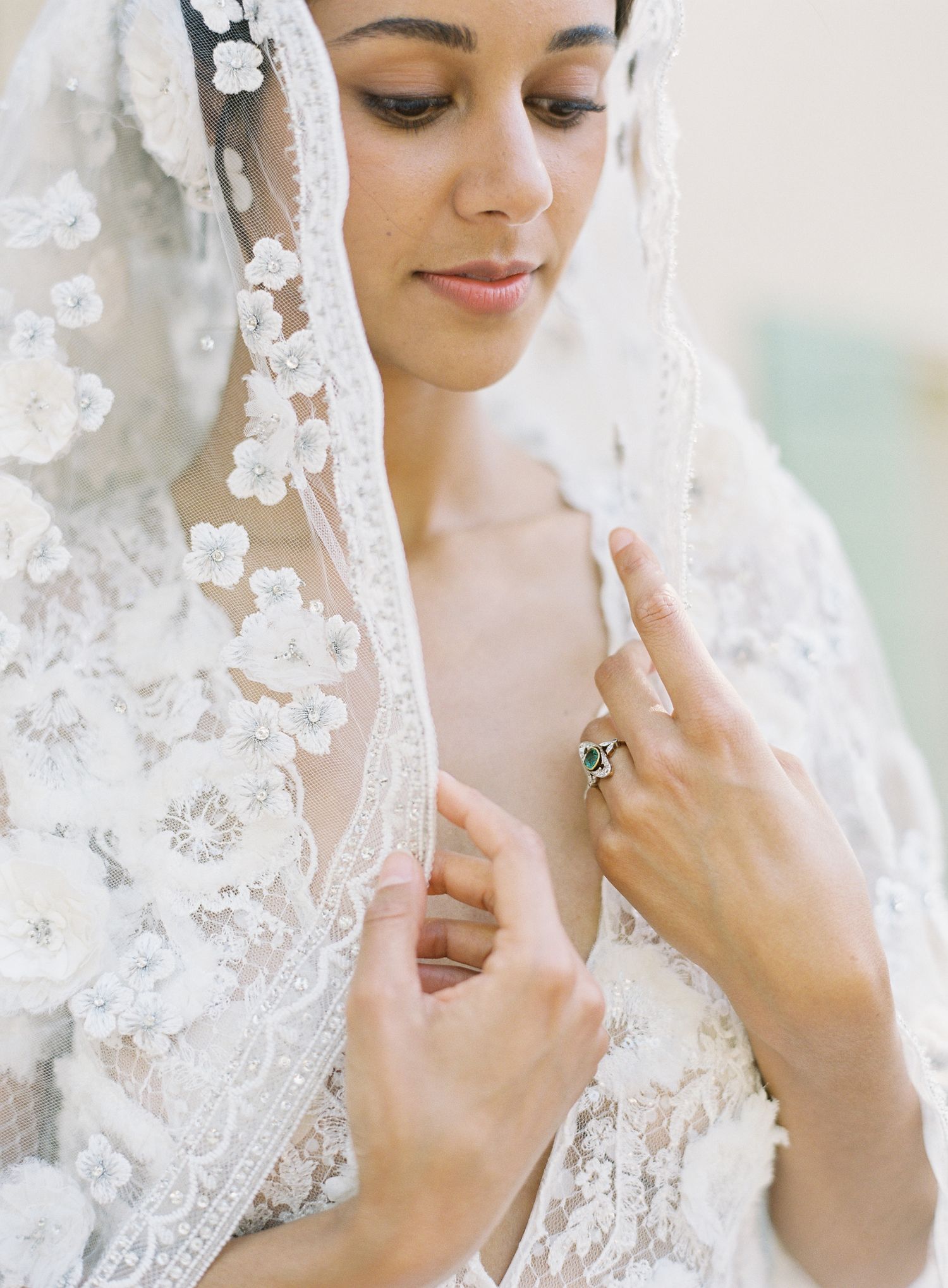 Detail shot of delicate lace veil and wedding jewelry on a bride.