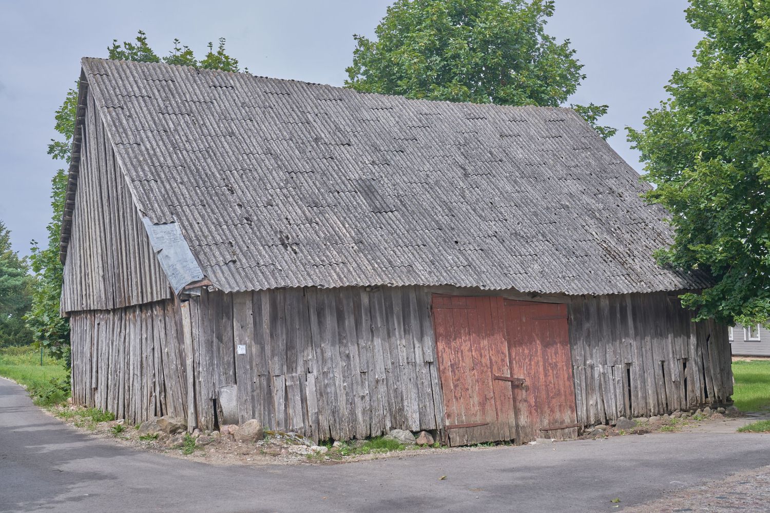Weathered wooden barns with rustic siding shown from different perspectives in a rural setting.