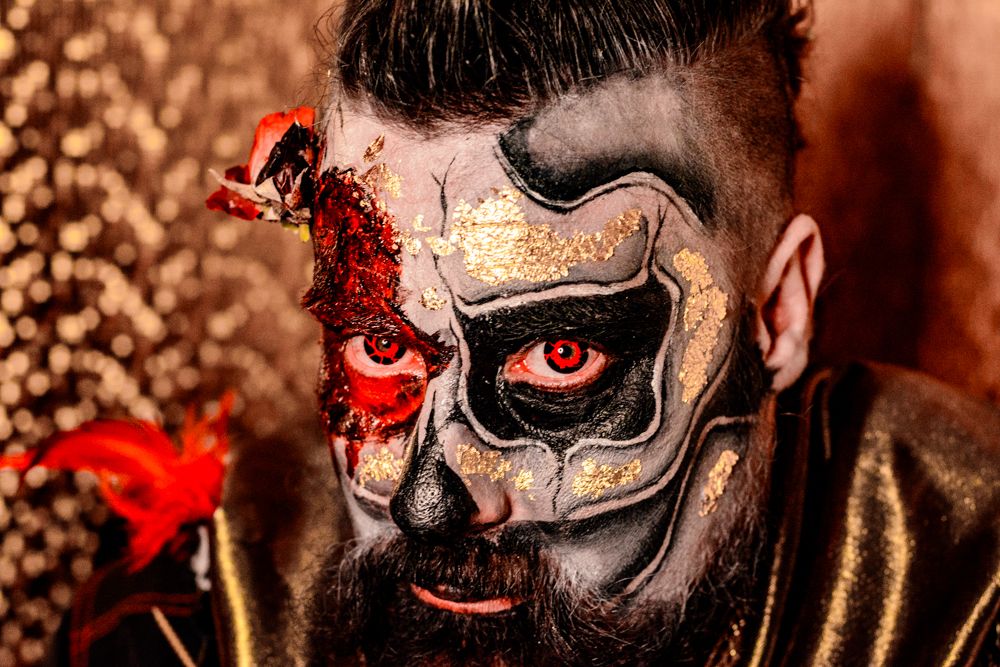 Detailed skull face paint design featuring black and white patterns with red accented eyes.
