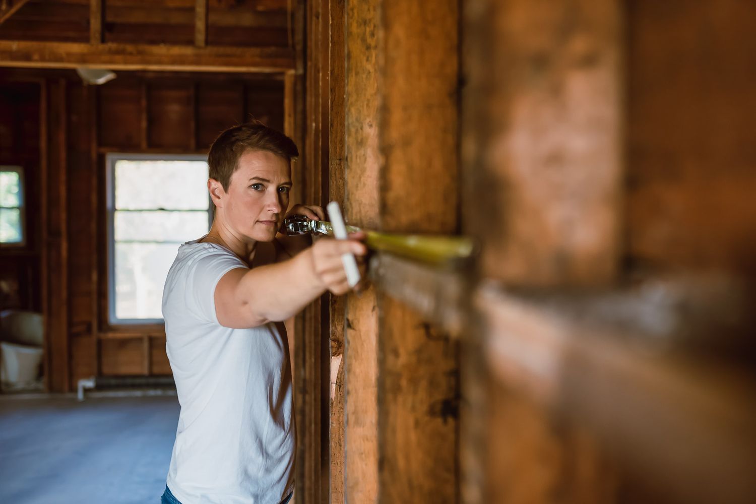 female contractor measuring a wall during a personal brand photo shoot