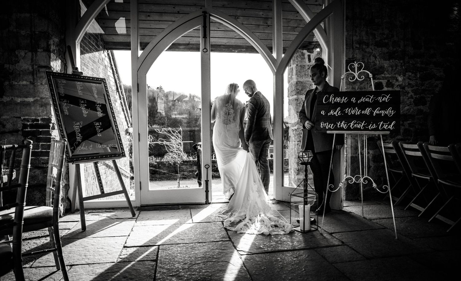 Dramatic black and white silhouettes of a wedding couple in a rustic barn setting.