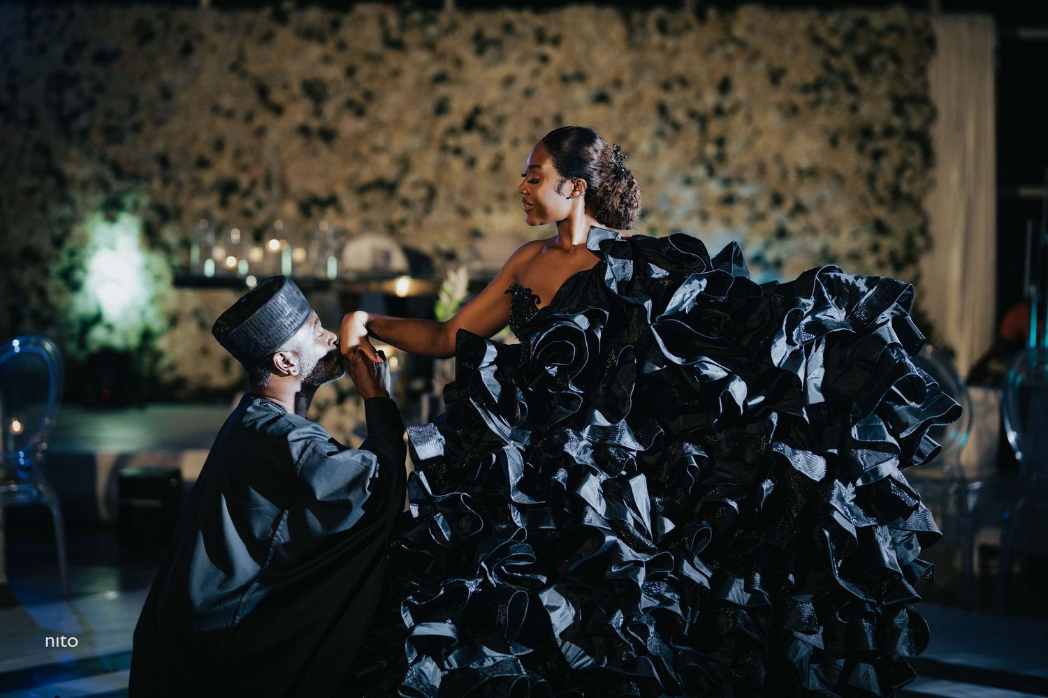 A dramatic moment at a wedding celebration with a flowing black ruffled dress.