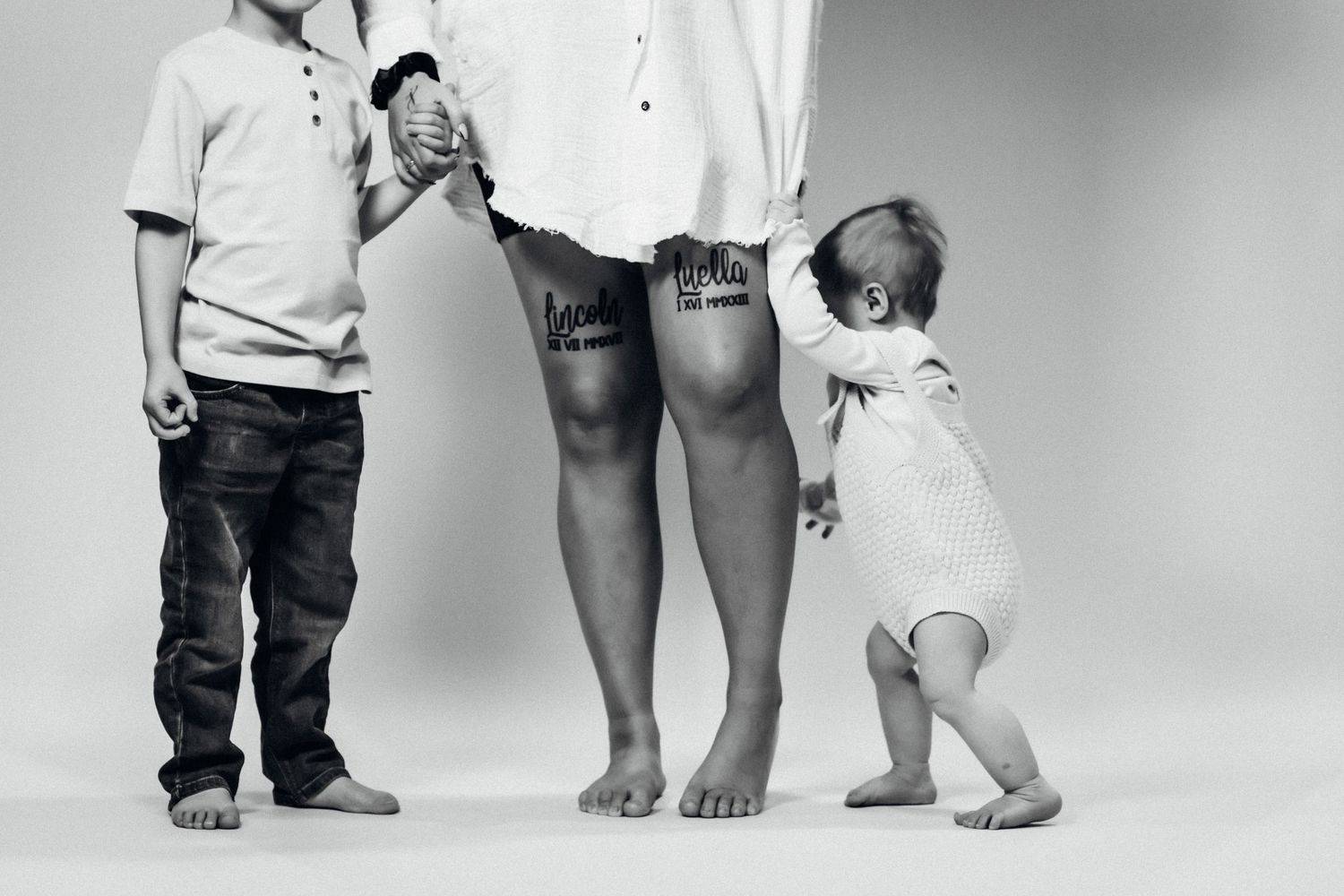 Black and white family portrait showing legs and feet in casual attire.