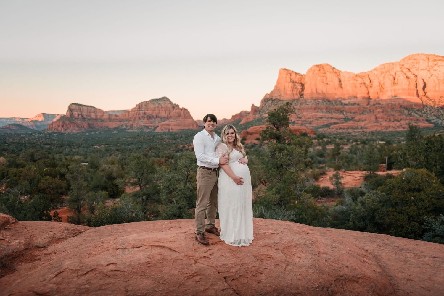 Romantic sunset photography session on red rocks in Sedona with mountain views.