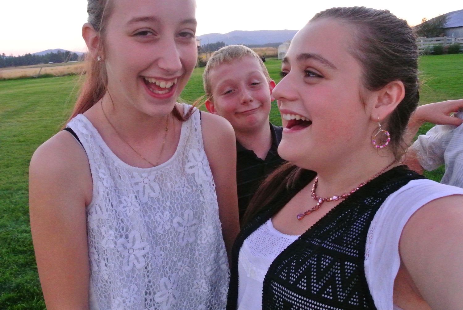 Three people taking a selfie outdoors, laughing and having fun.