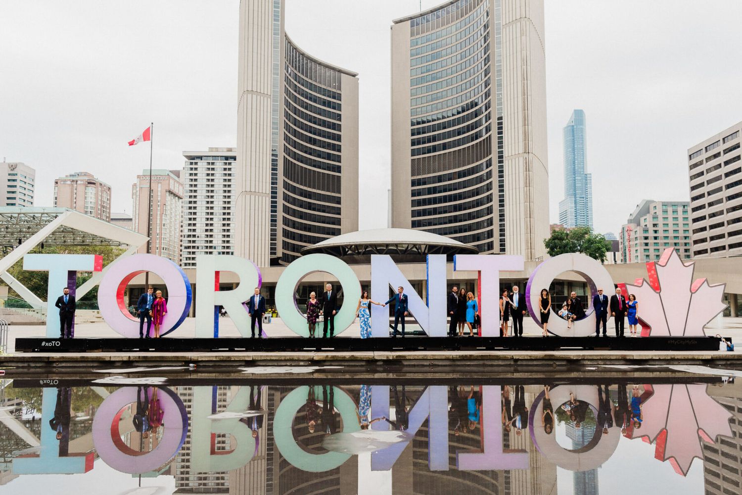 Toronto city skyline with Nathan Phillips Square and colorful TORONTO sign in the foreground.
