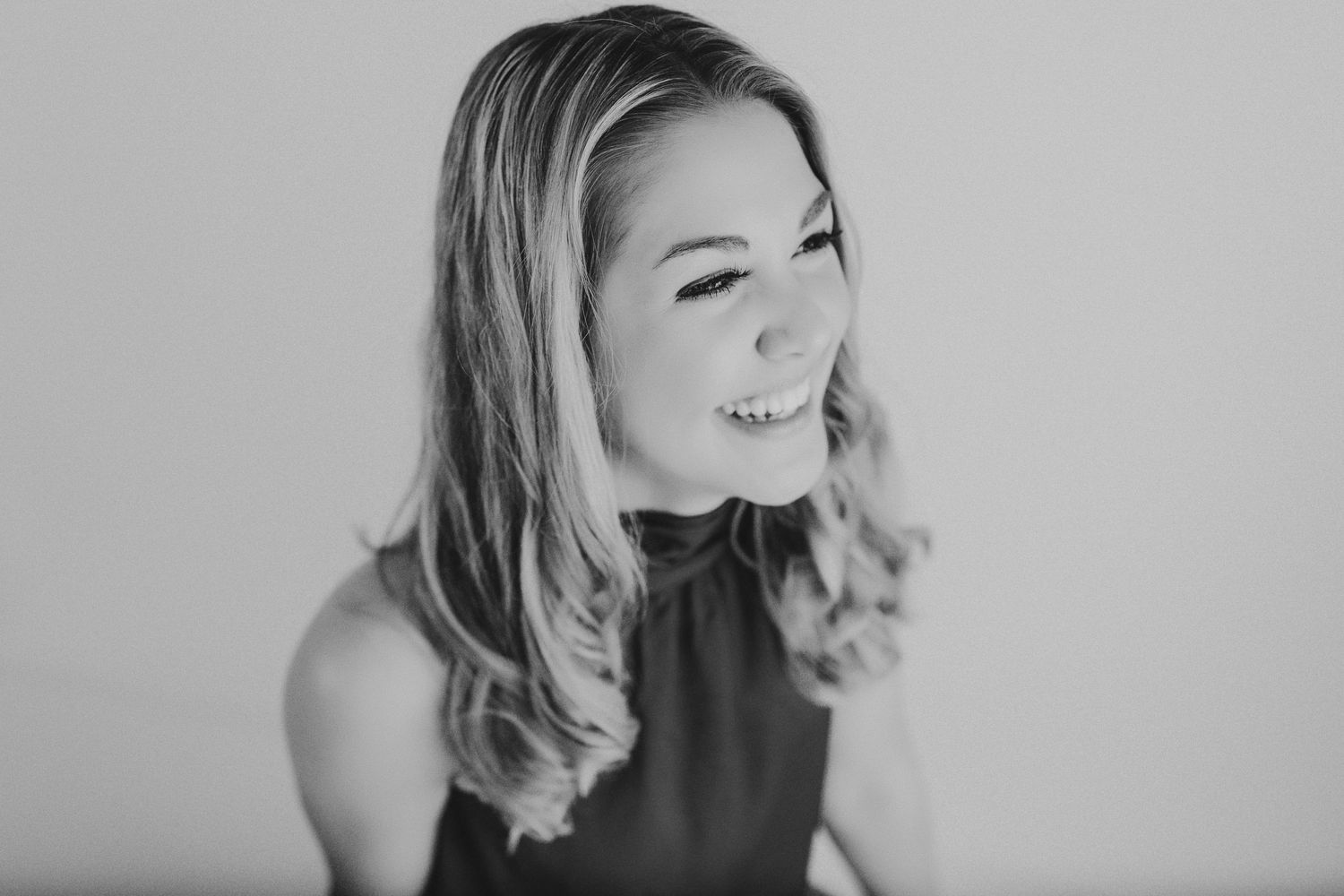 Professional black and white headshot of woman with blonde hair smiling.