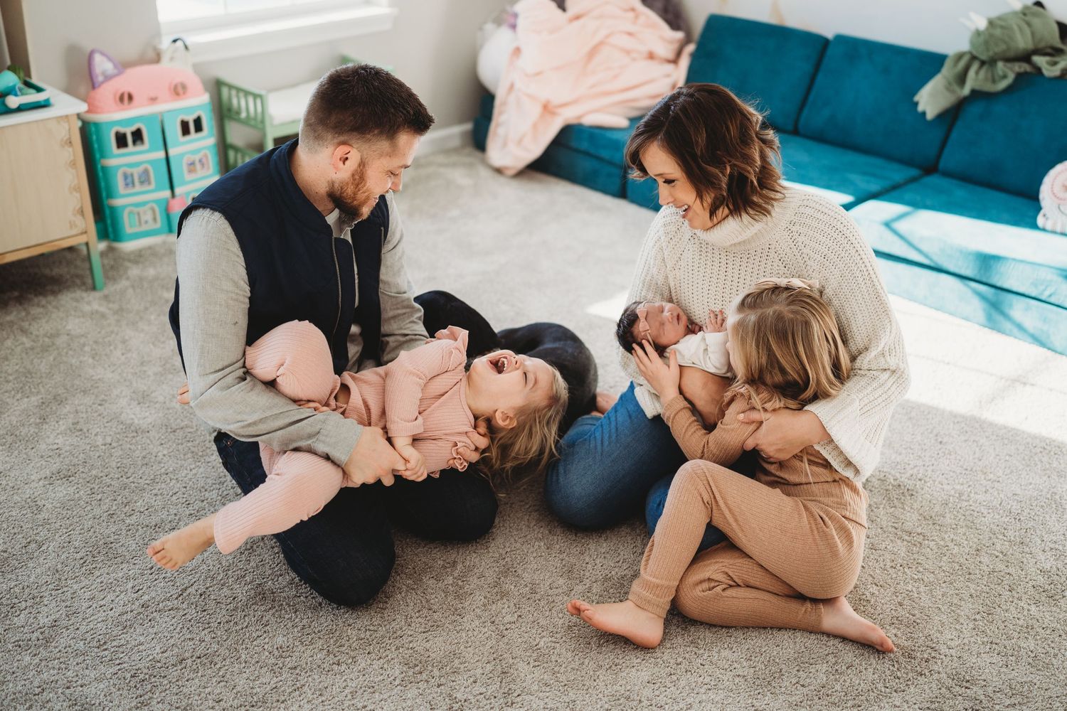 Family enjoying playful moment together on living room floor.