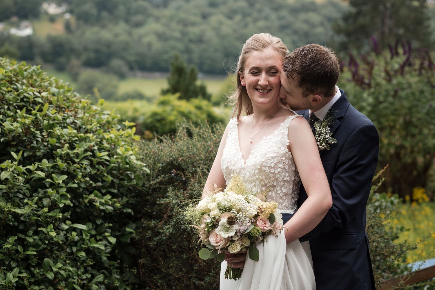 Lovely garden wedding scene with lush greenery and flowers in the background.