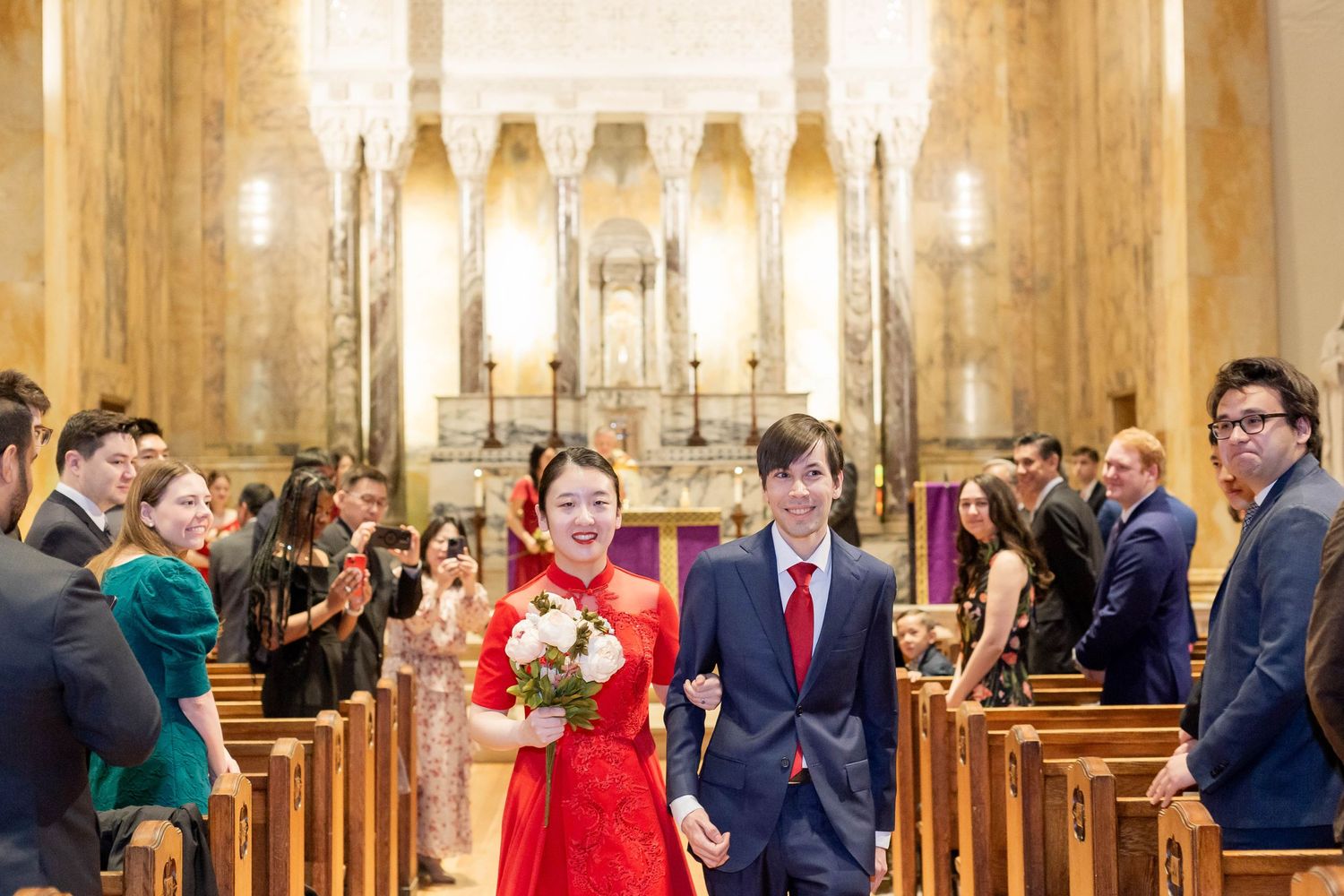 Wedding ceremony in traditional church with tall columns and elegant lighting.