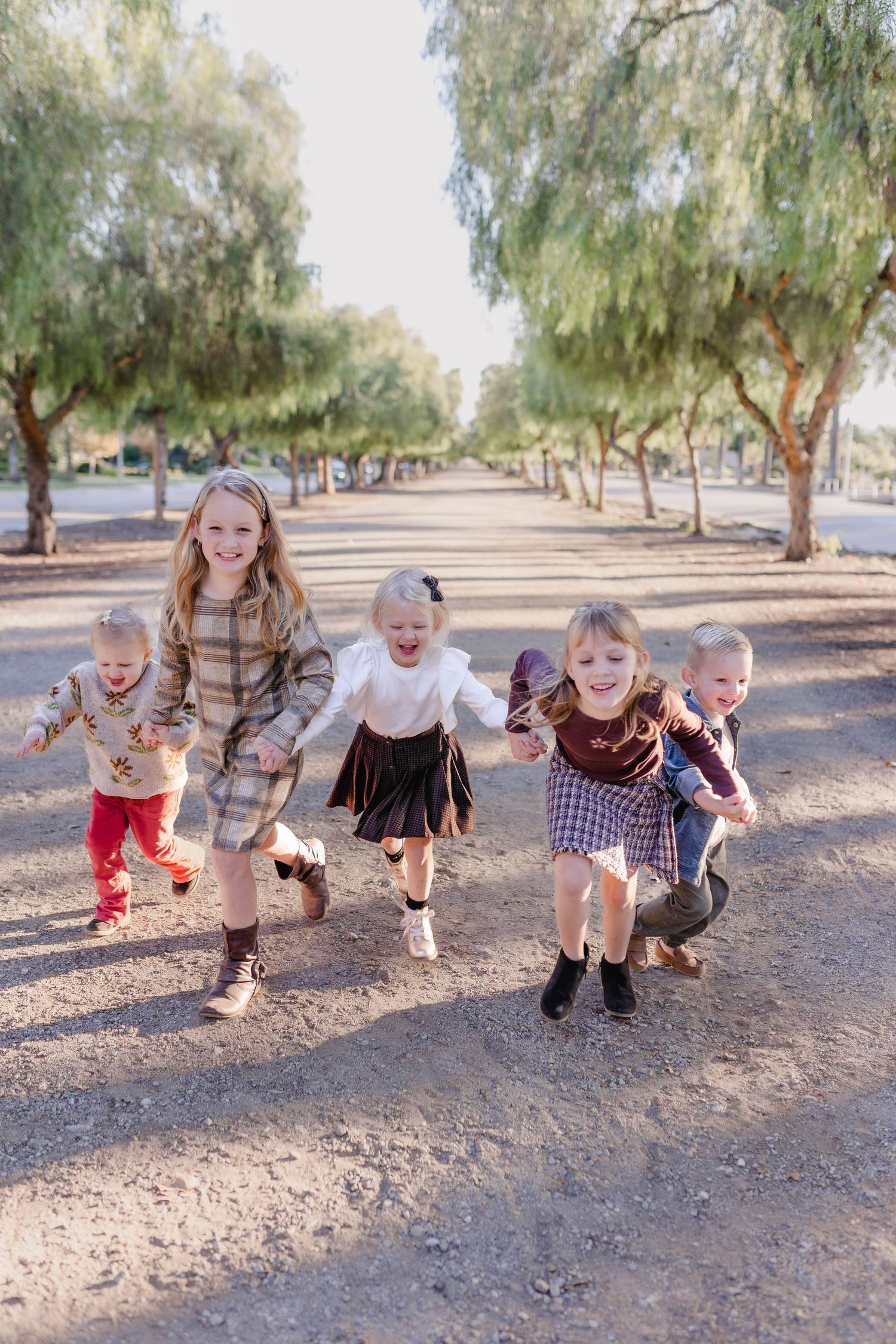 young children cousins running dirt road family style photos blonds