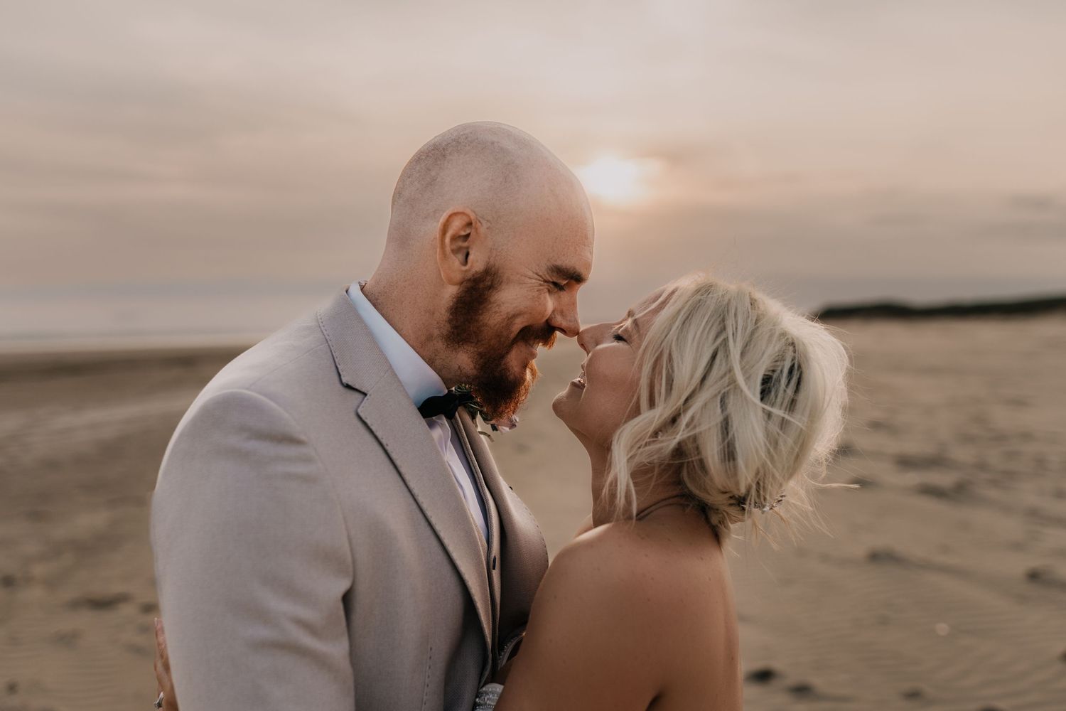 Romantic sunset moment on beach with soft pink sky.