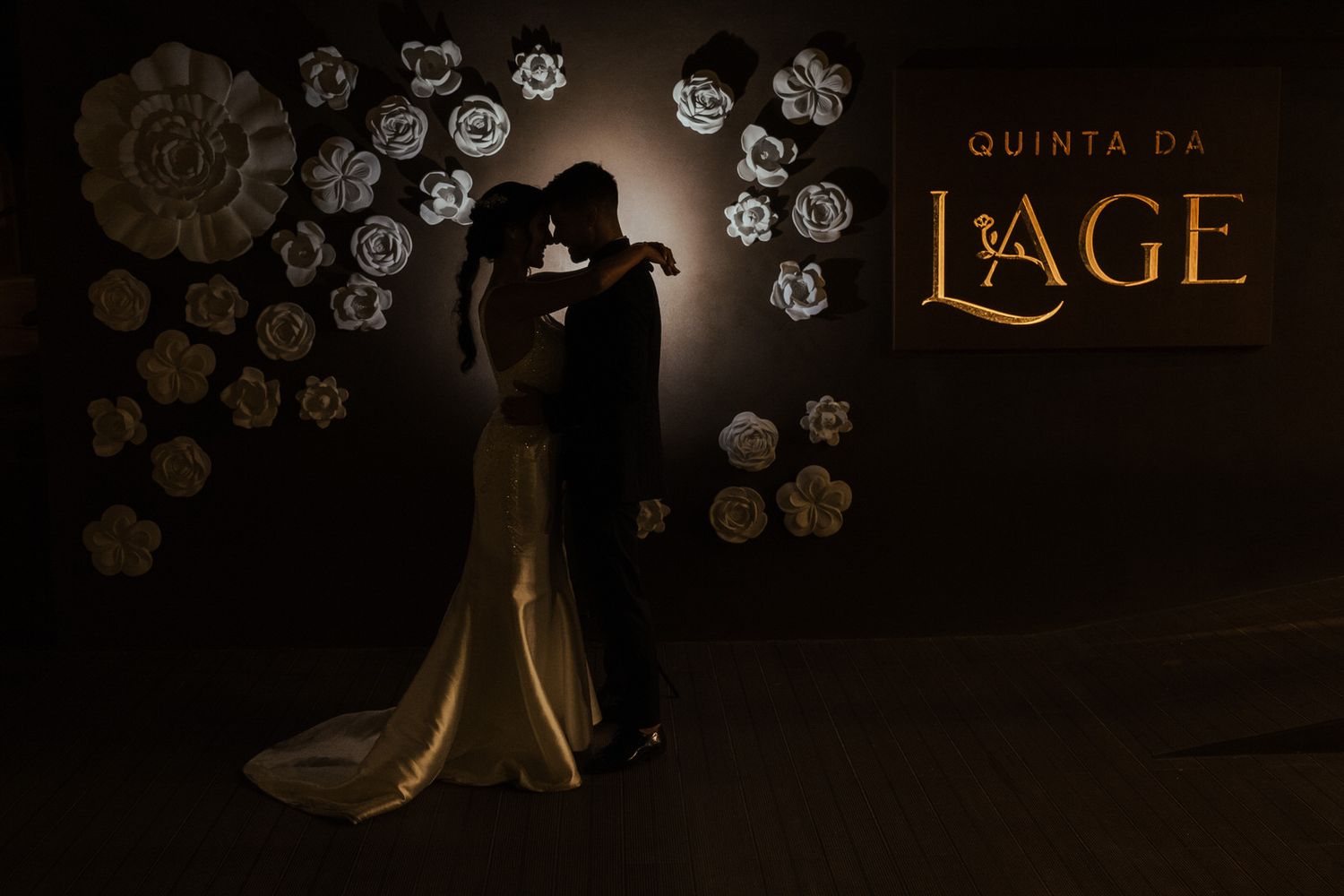 Silhouettes of dancers performing against a dark backdrop decorated with illuminated snowflake patterns.
