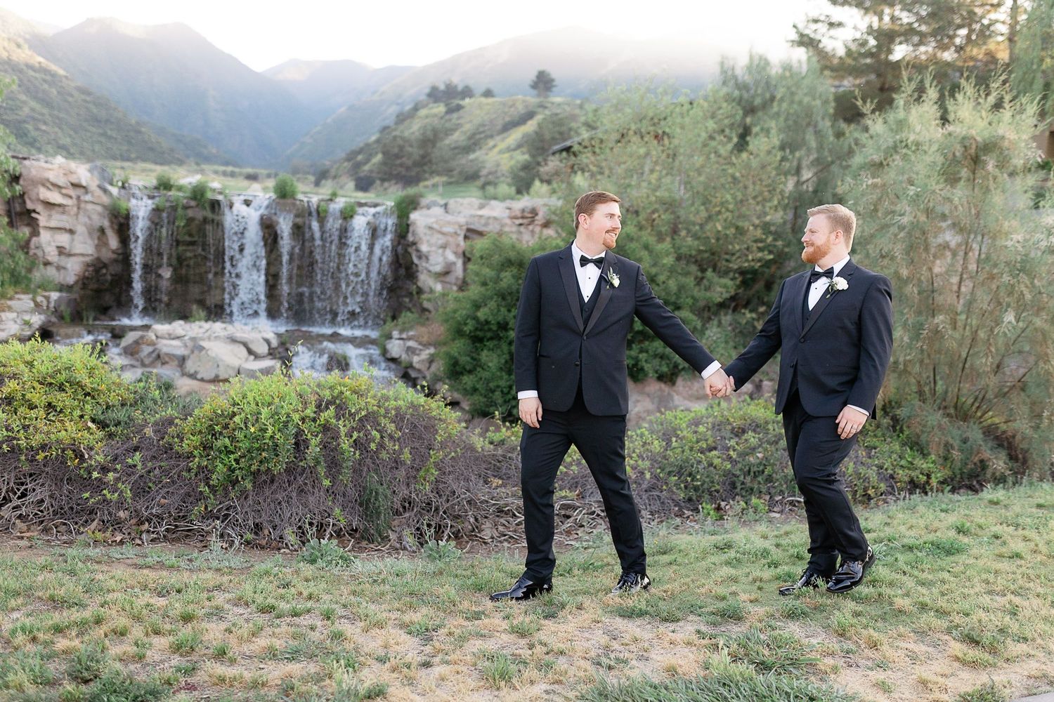 Groom and groom wedding holding hands waterfall