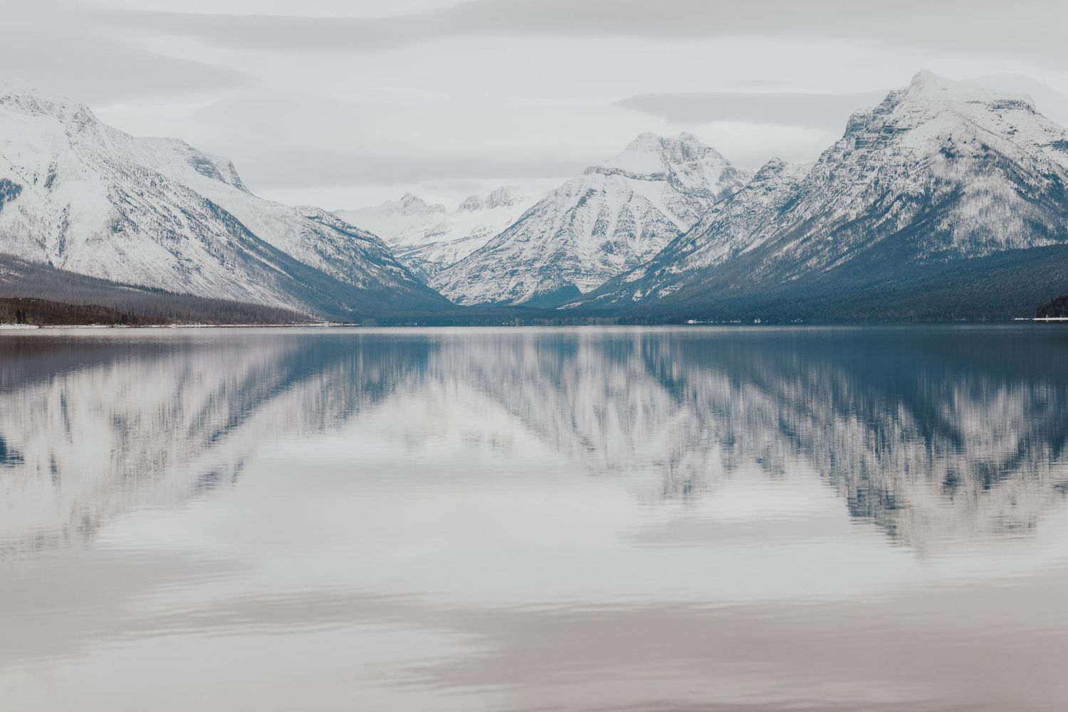 Glacier National Park with snow covered mountains reflecting off of Lake McDonald