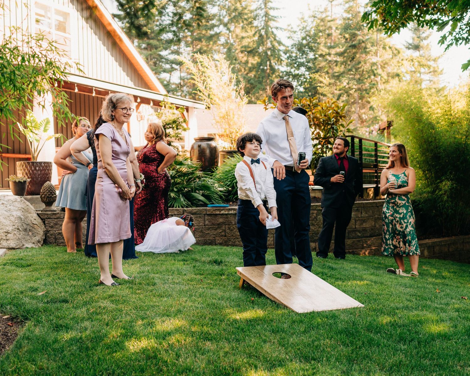 Wedding guests enjoying outdoor lawn games during garden reception celebration.