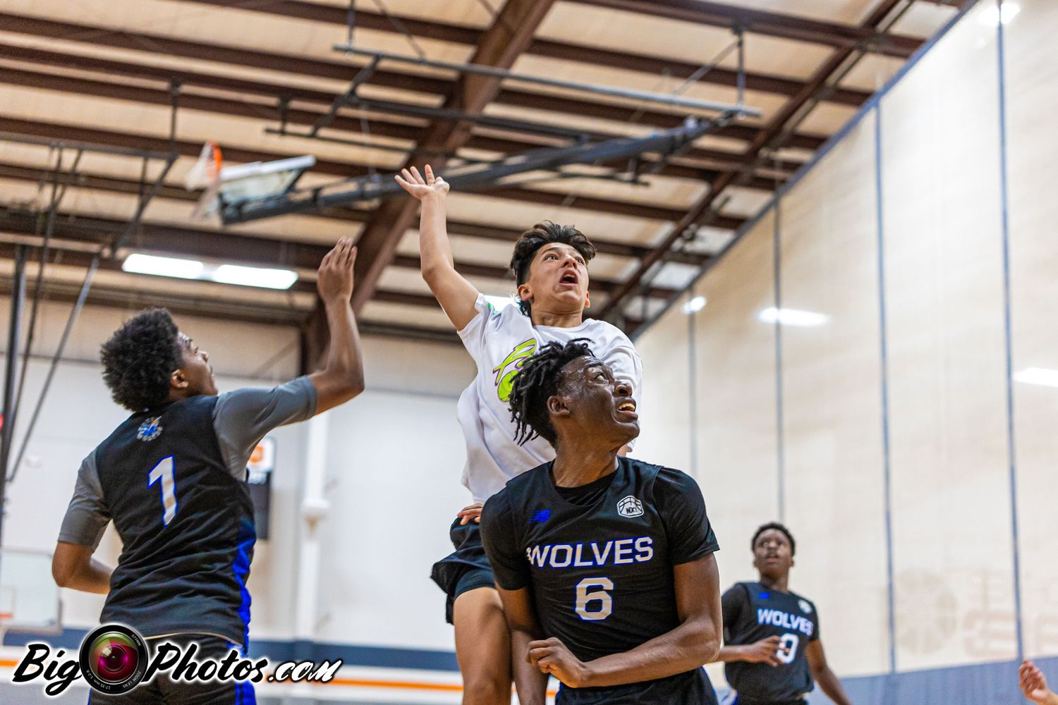Basketball players compete during an intense indoor game with multiple action shots.