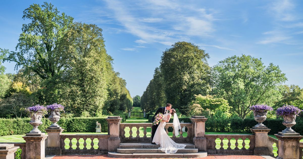 Groom dipping the bride for a kiss in the beautiful gardens of Old Westbury Gardens