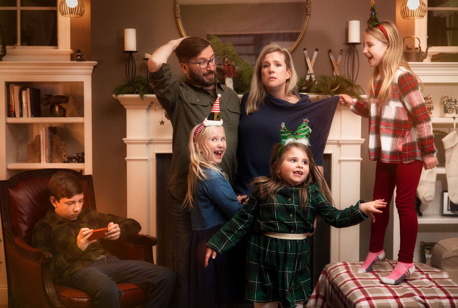 A festive indoor gathering with people in holiday attire celebrating around decorated built-in shelving.