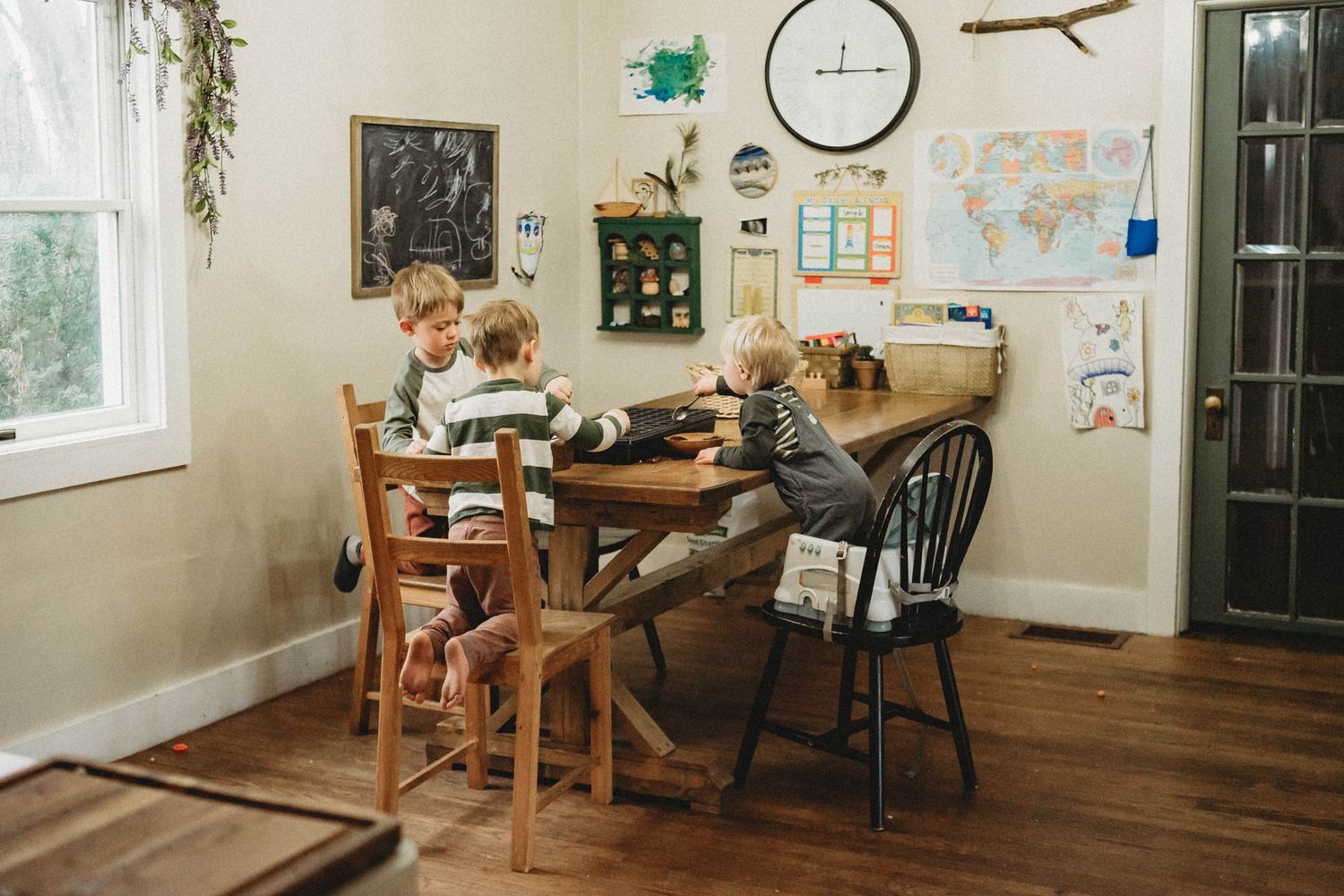 Homeschool setup in a cozy corner with maps and educational materials on the wall.