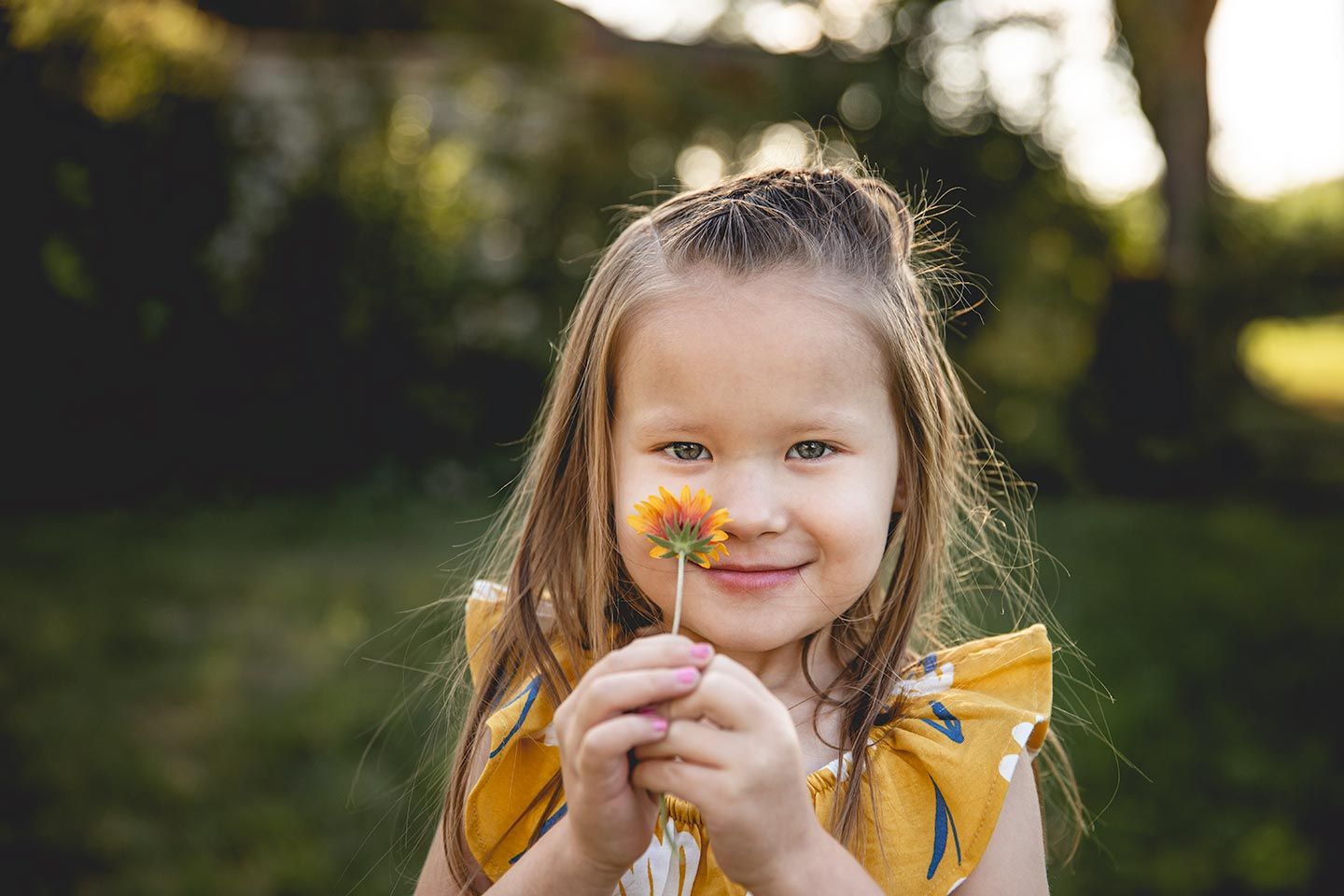 toddler girl smelling a wildflower at Olmstead Place State Park