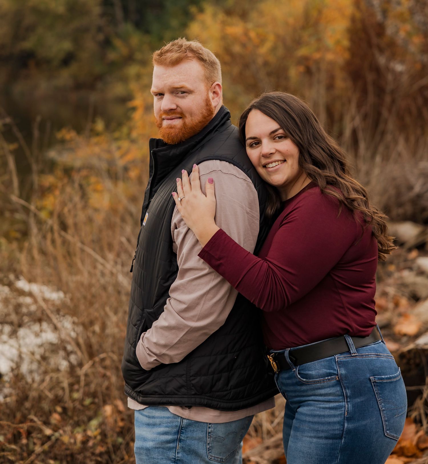 Casual couple embracing outdoors during an autumn photoshoot with warm fall colors.