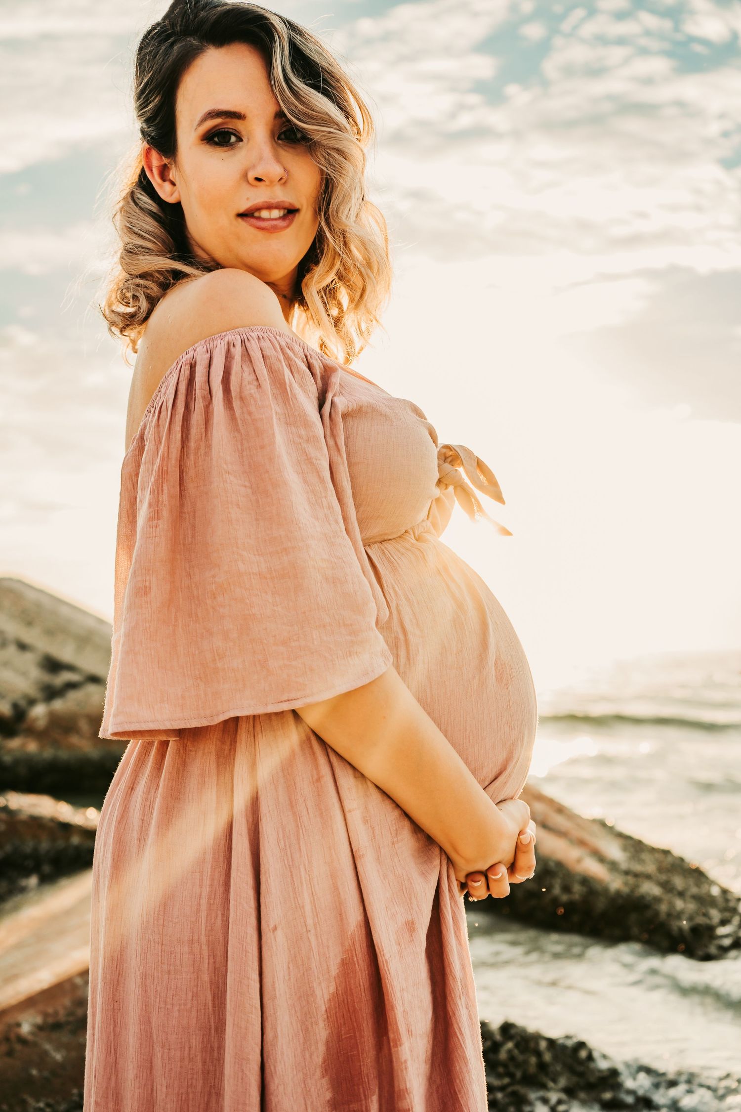 Outdoor Maternity Session at Ft. Desoto in St. Pete, FL; woman bathed in sunlight on the beach at sunset