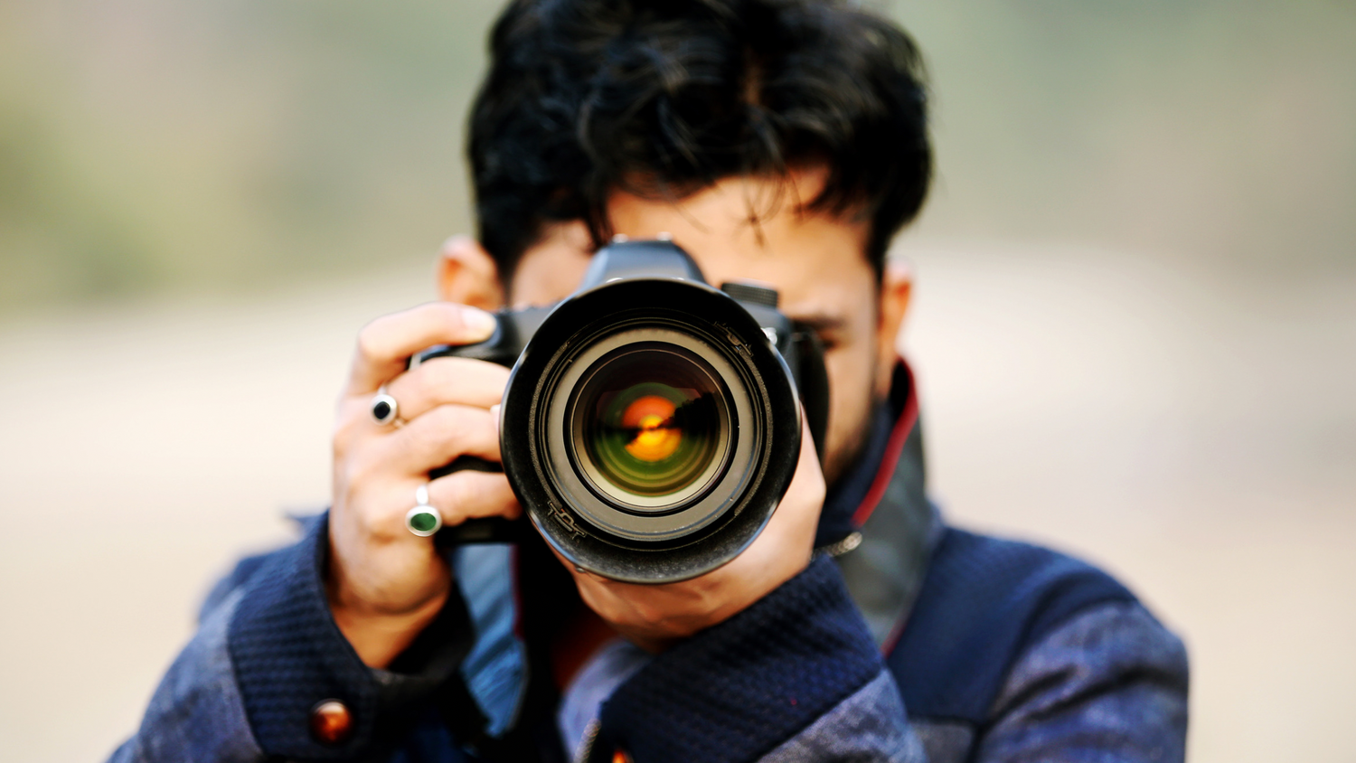 Professional photographer taking photo with DSLR camera and telephoto lens.