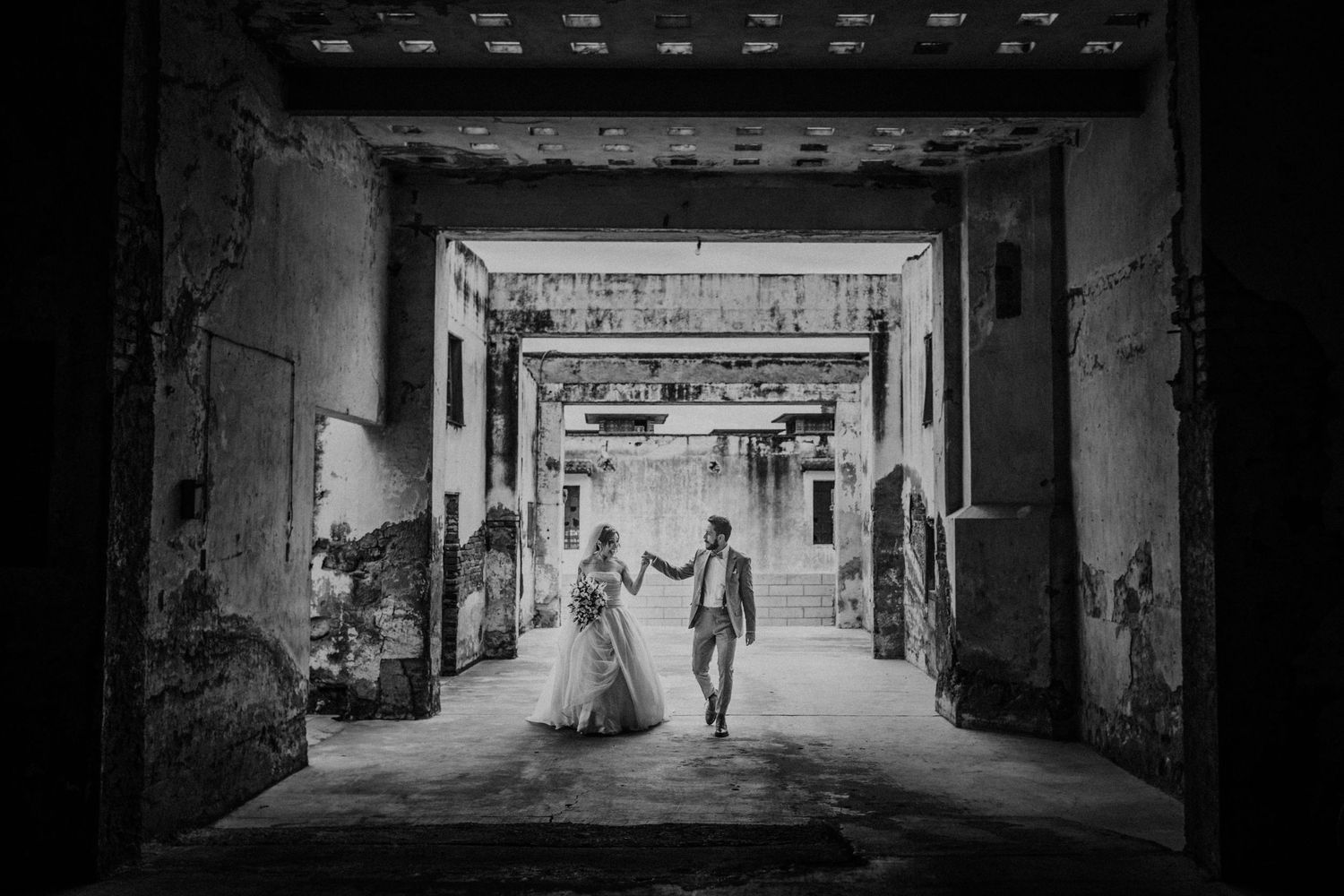 Dramatic black and white shots of a couple in an industrial corridor.