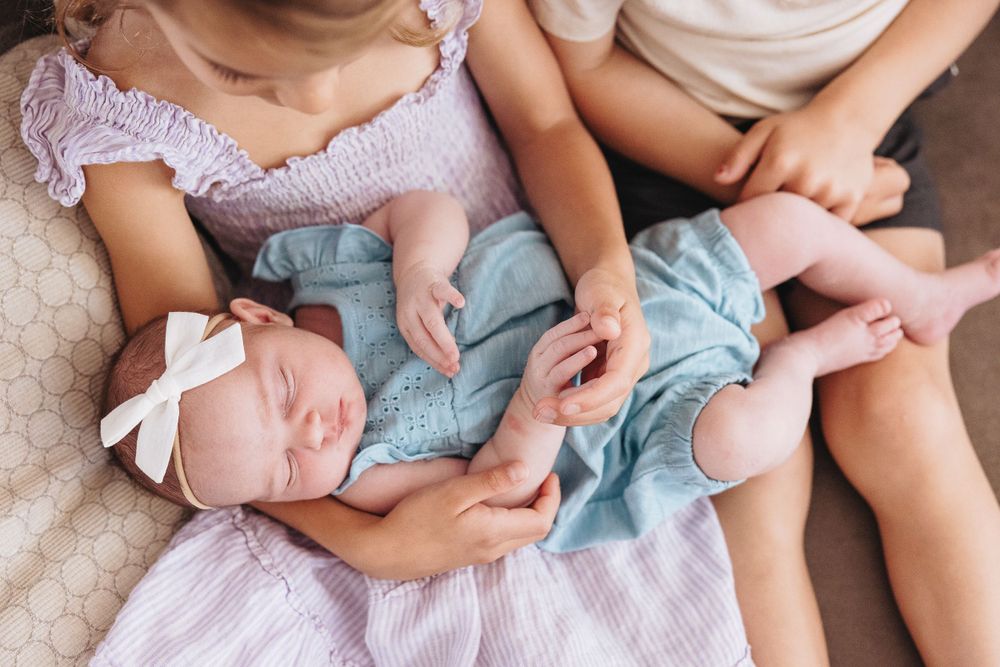 Intimate family lifestyle photography showing gentle moments of connection on a sofa.