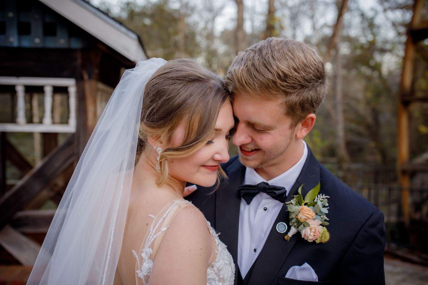 A romantic moment between newlyweds as they share an intimate pose during their forest wedding portraits.