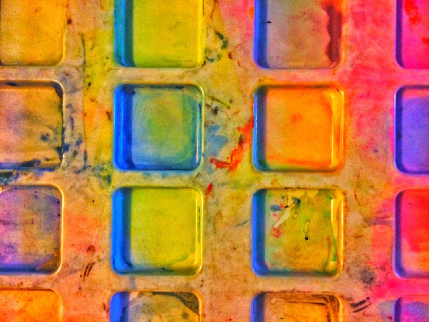 Vibrant watercolor paint palette with colorful squares arranged in a grid pattern.