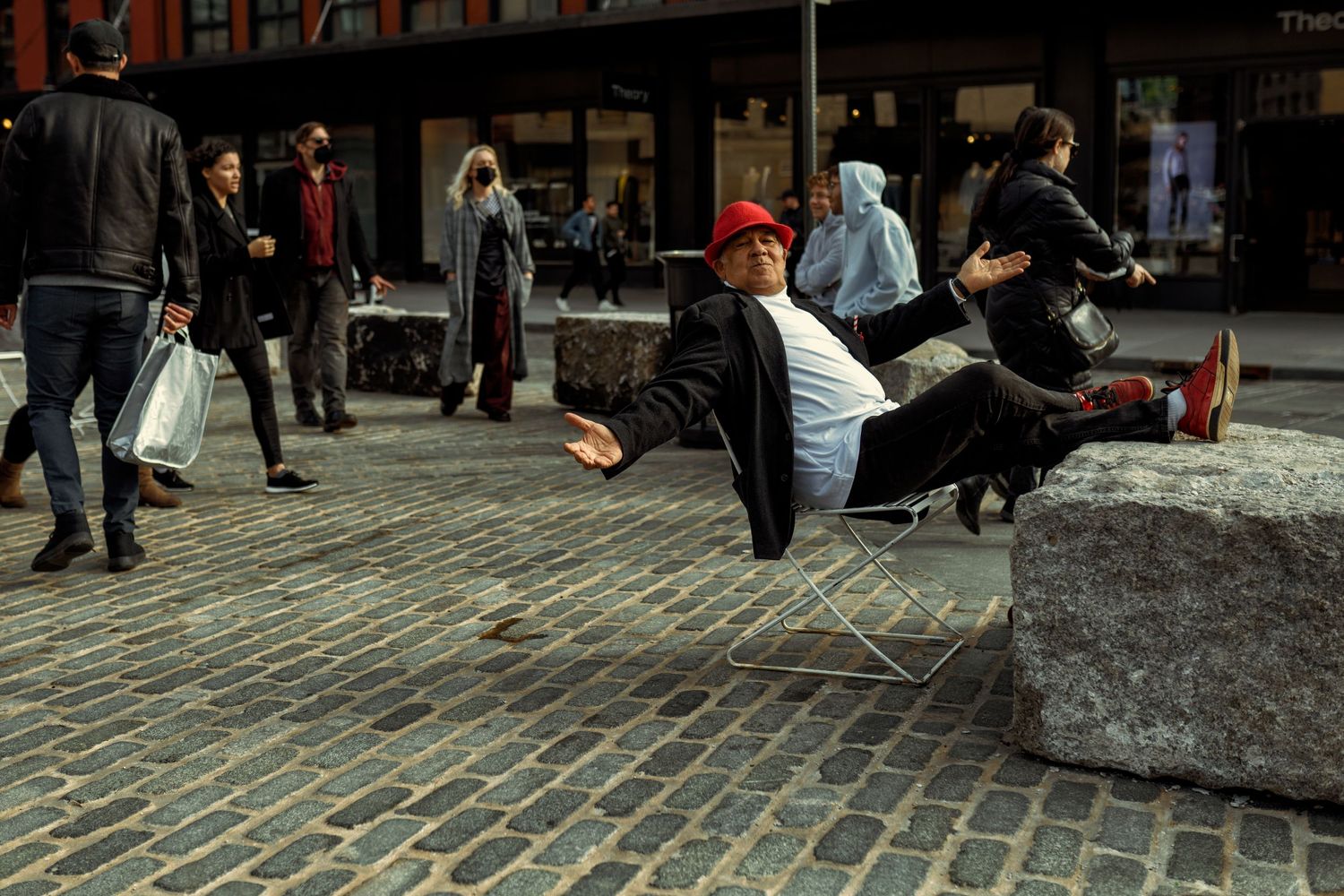 Break dancer performs acrobatic moves on cobblestone street while crowd watches.
