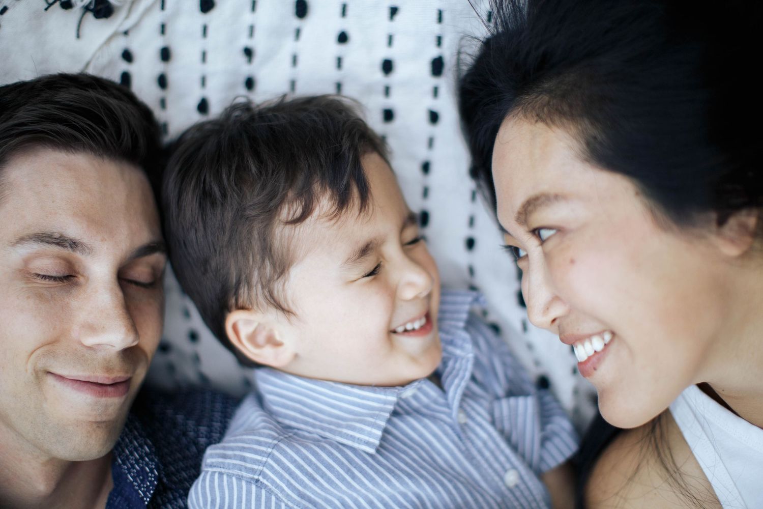 Everett family photographer: Candid photo of parents laying on a blanket with their son at a family photo session
