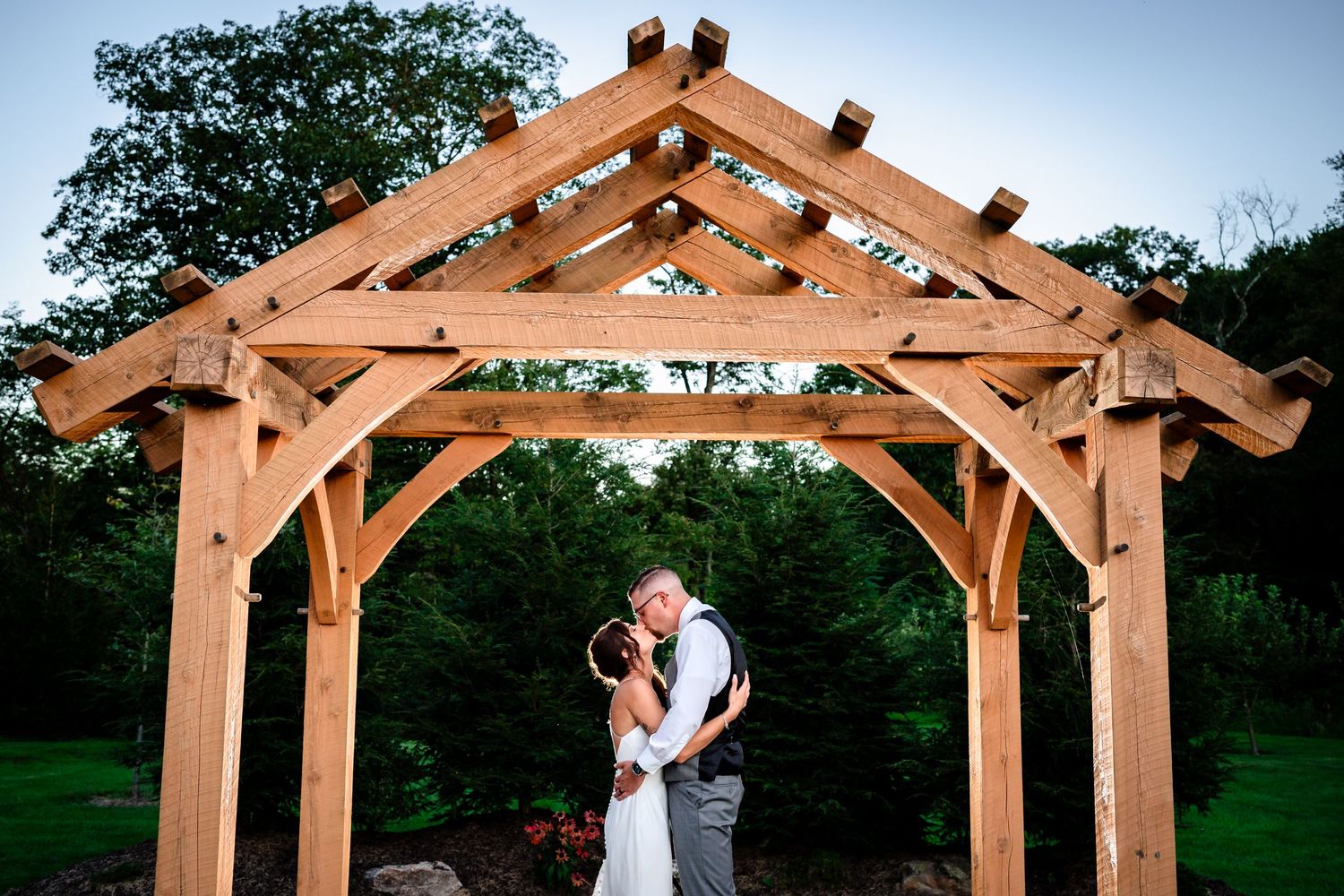 A wooden pergola structure in a garden setting with decorative timber beams.