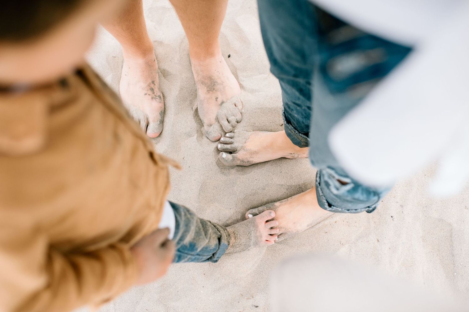 Bare feet in the sand during a beach family photoshoot.