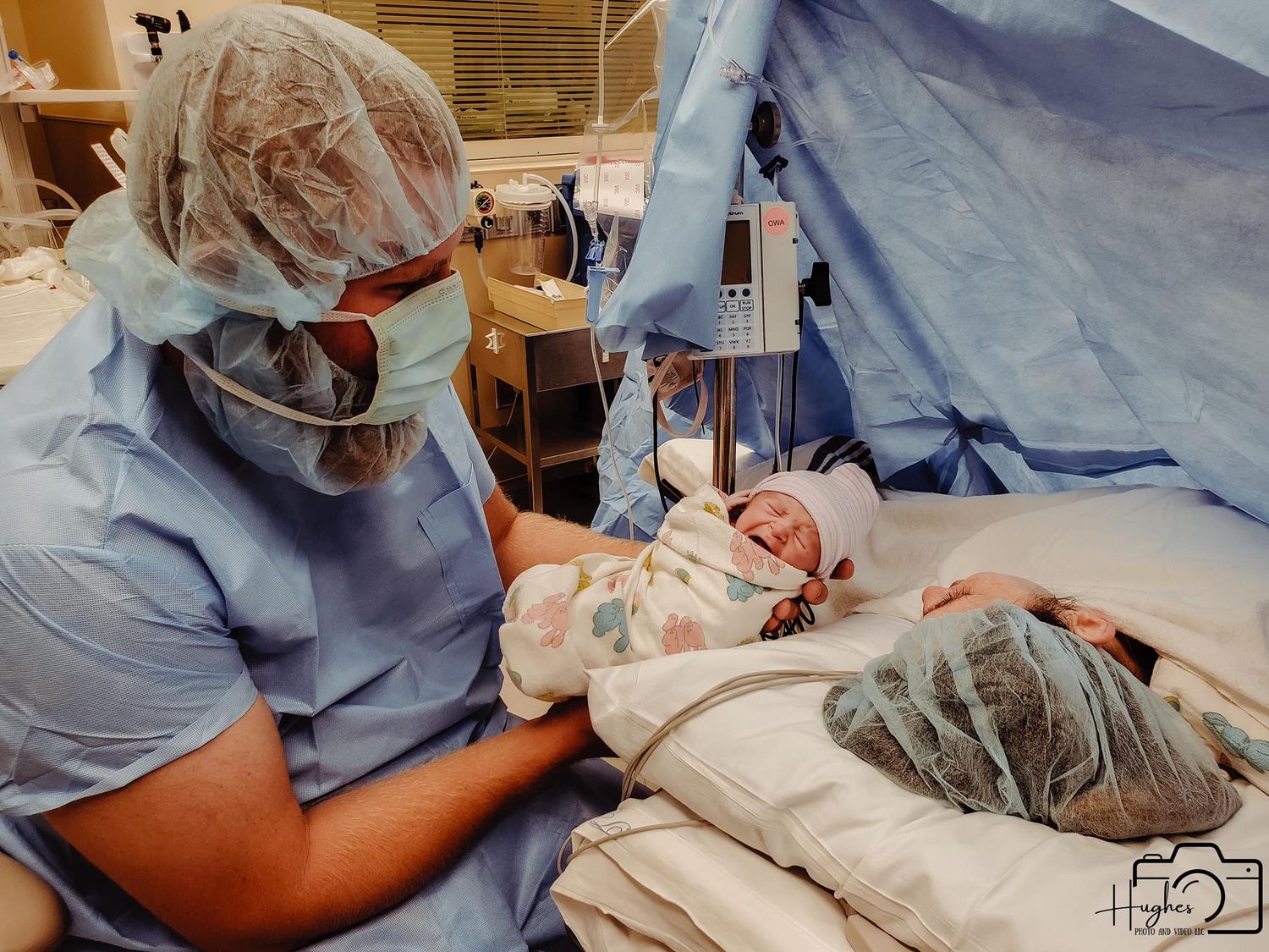 Medical staff attending to a newborn baby in a hospital delivery room.