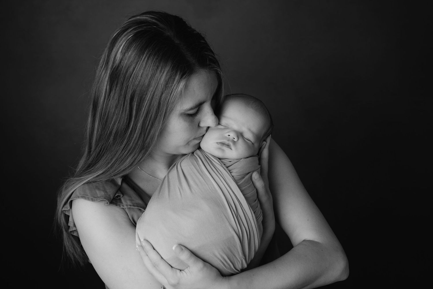 Tender black and white portrait of maternal embrace.