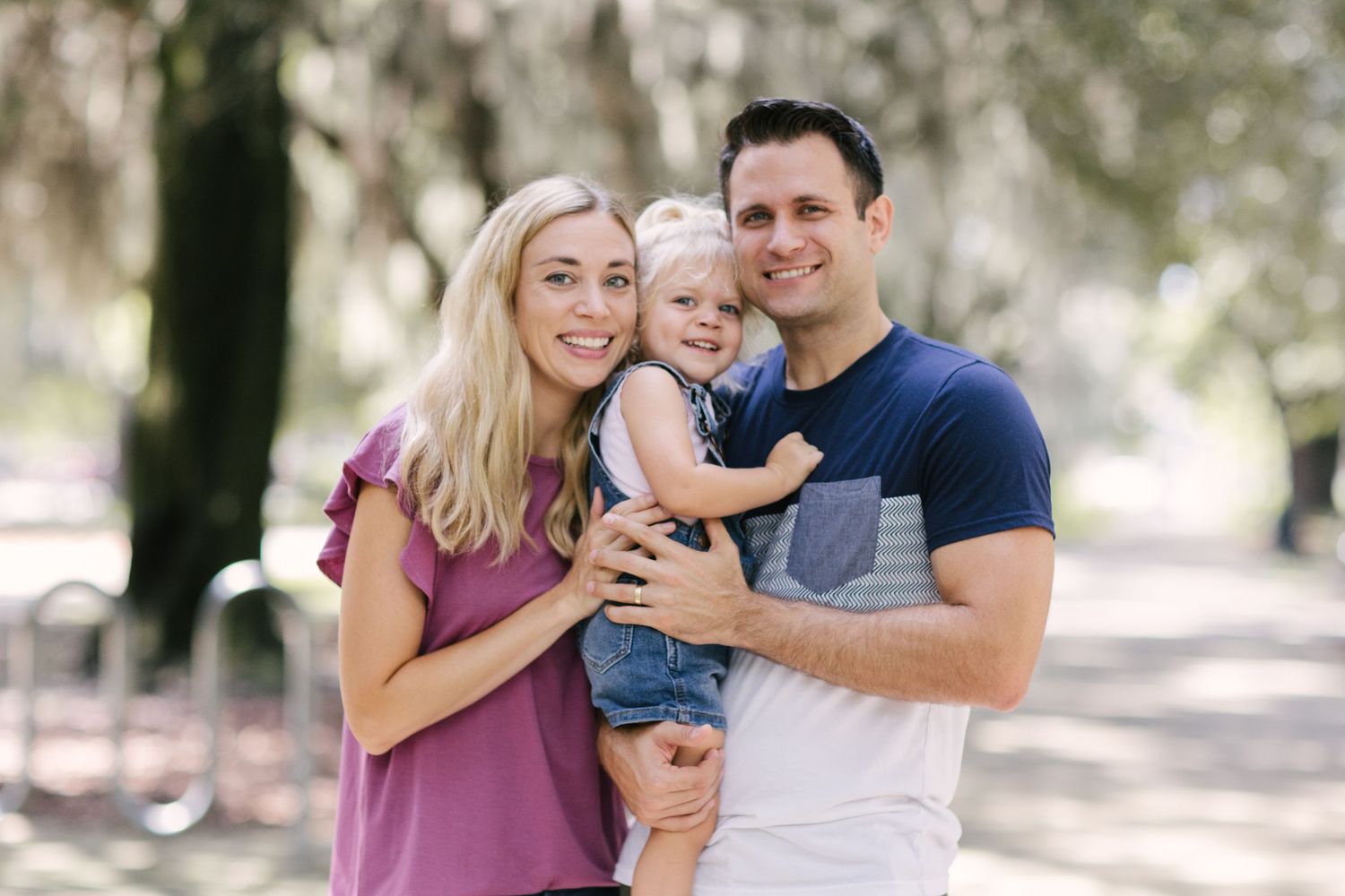 A loving family embracing outdoors in casual clothing.