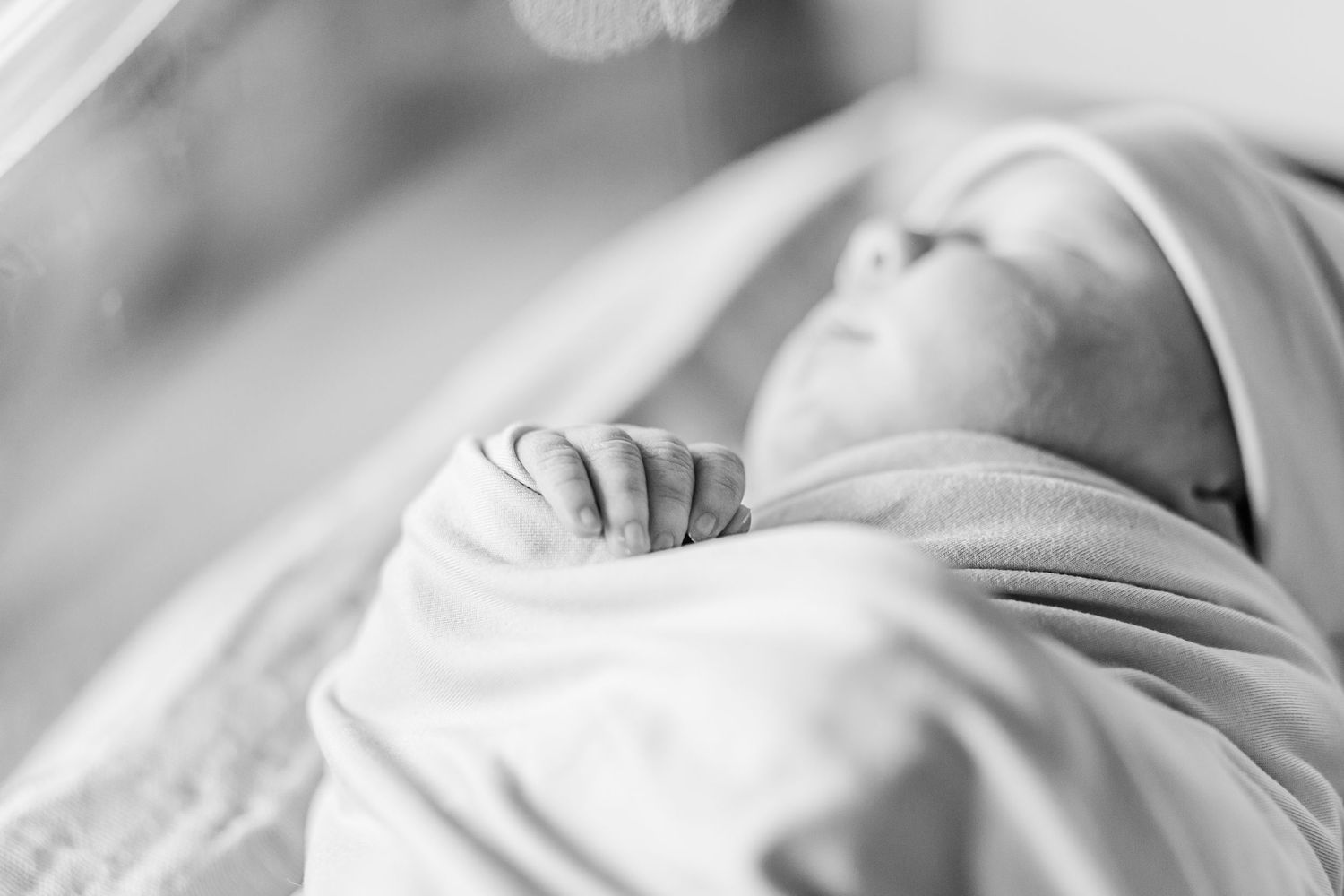 Close-up black and white image of a newborn baby's hand.